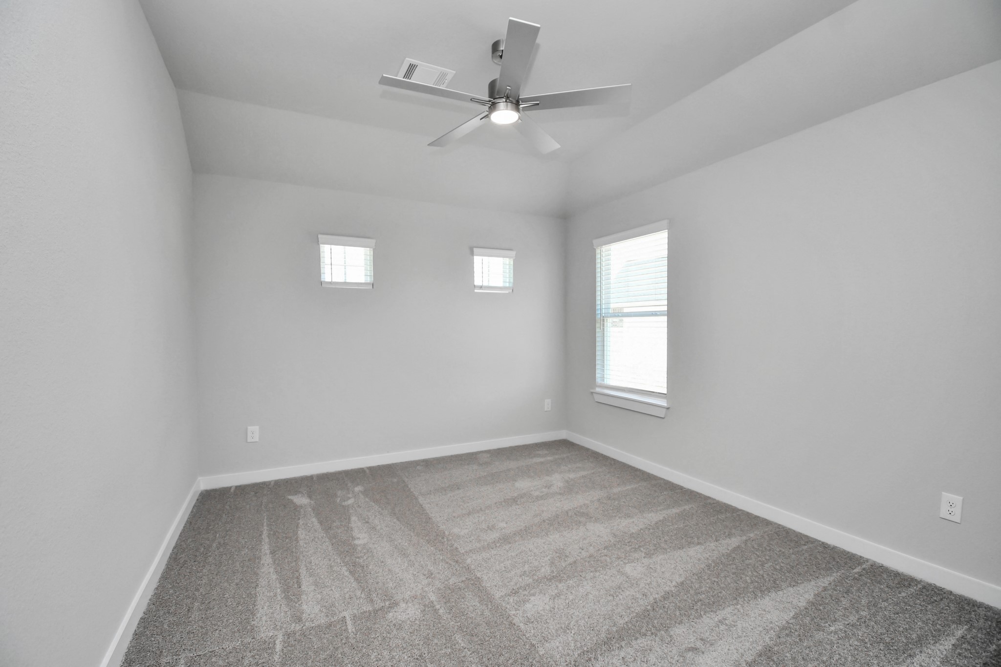 Secondary bedroom features plush carpeting, large windows that let in plenty of natural light, bright paint, and spacious closets. Sample photo of completed home with similar floor plan. Actual colors and selections may vary.
