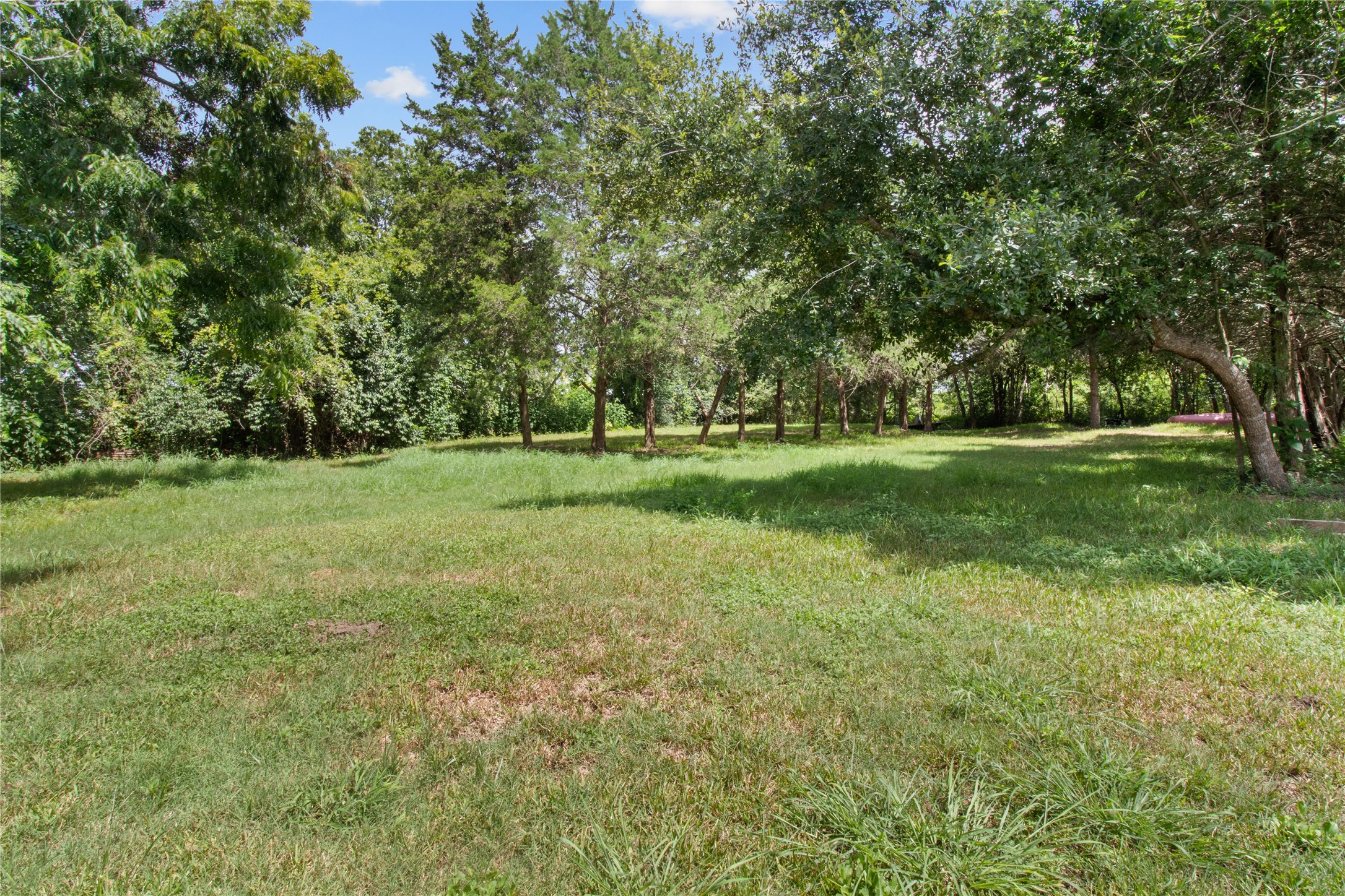 Mature trees provide natural screening throughout the property while the approximately 2-acre tract offers room to reimagine the site.