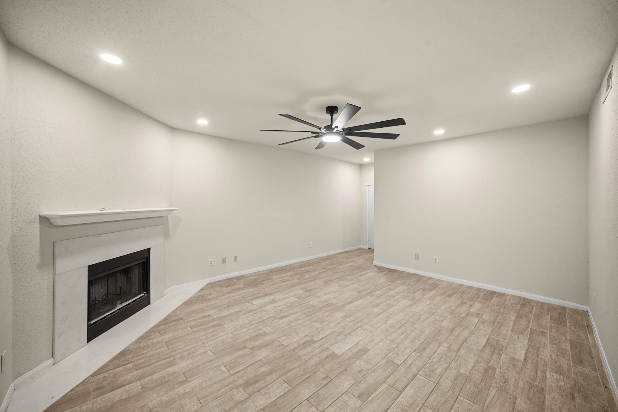 View of living area from back of condo showcasing the cozy fireplace.