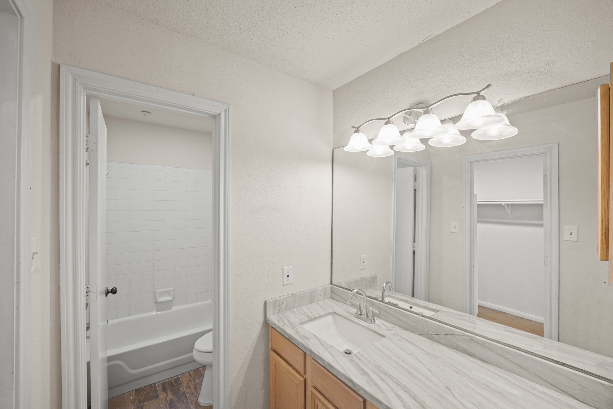 Bathroom features a modern vanity with a large mirror, complemented by stylish lighting.