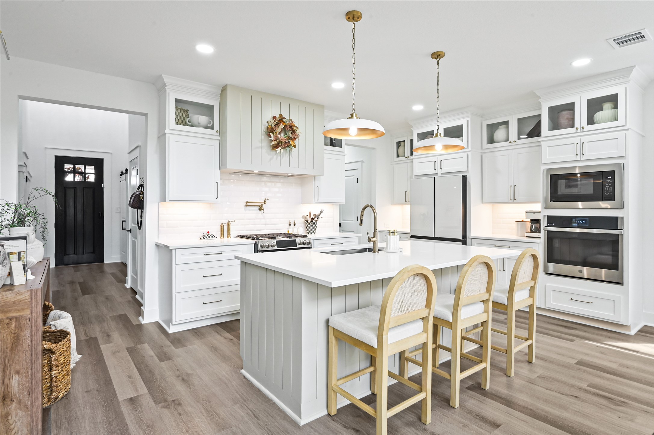 Professional-style gas range, white subway tile backsplash, under-cabinet lighting, and abundant storage