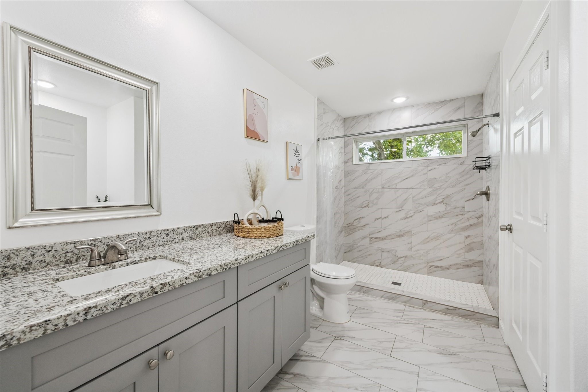 One of two dedicated vanities in the primary ensuite, offering ample storage, a wide granite countertop, and an undermount sinkperfect for everyday function and personal space.