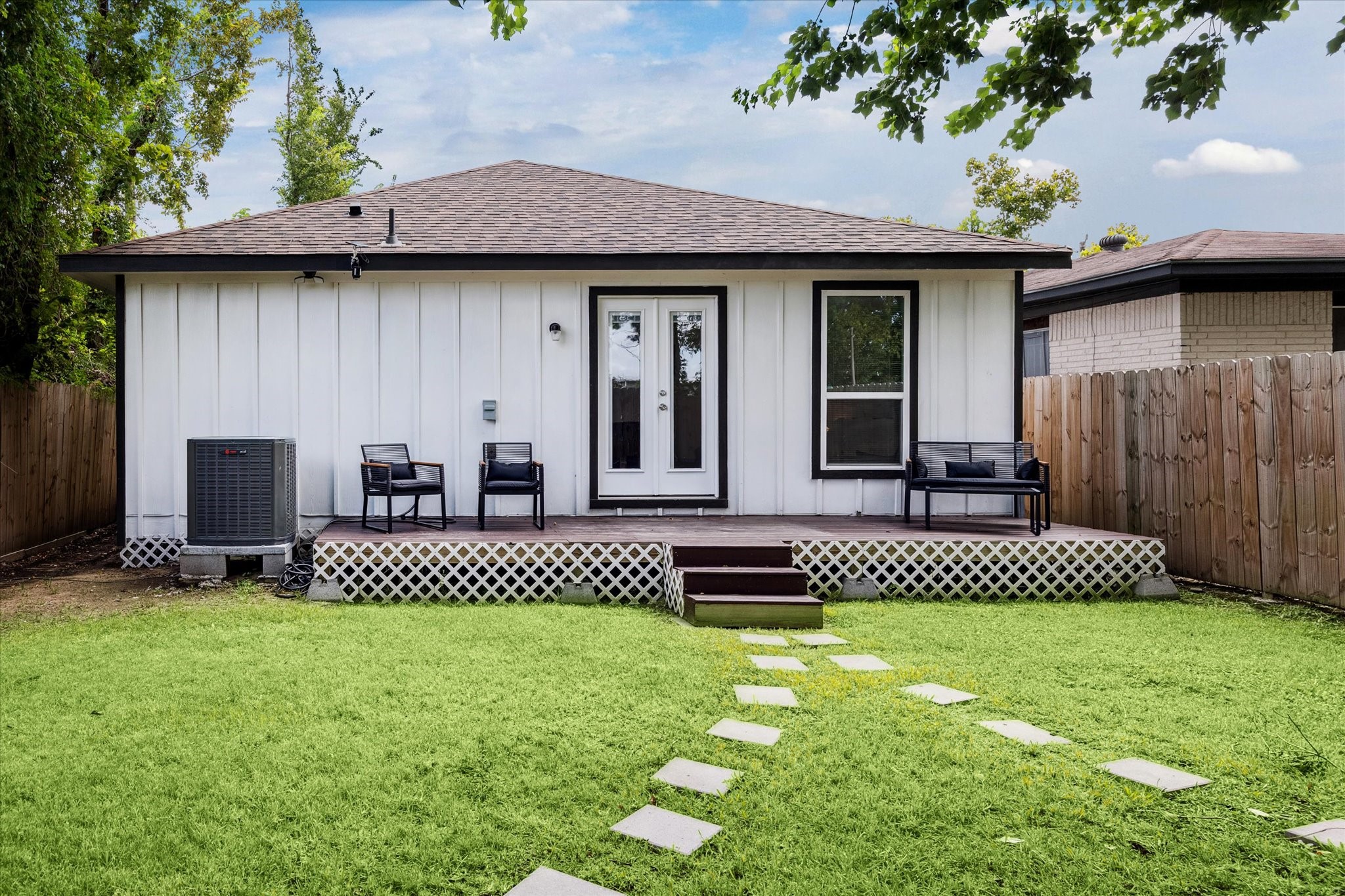 The fenced backyard features a deck with French door access, offering the perfect spot for outdoor seating or weekend gatherings. A private green space provides plenty of room for relaxation or play.