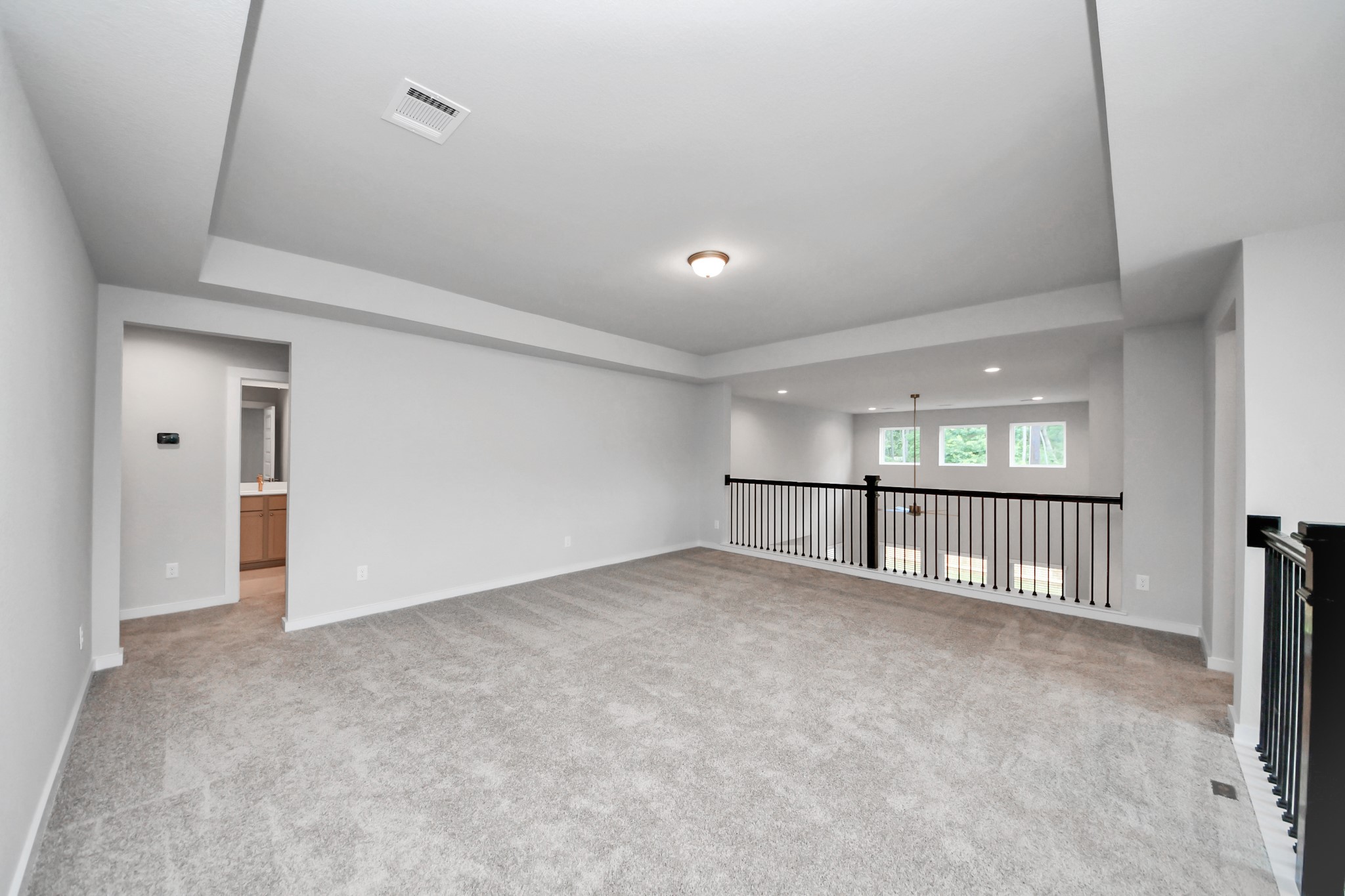 Ascend to relaxation in this fantastic game room! Ideal for both casual gatherings and adult gaming, it boasts plush carpet, lofty ceilings, custom paint, and ample windows for abundant natural light. Sample photo of completed home with similar floor plan. Actual colors and selections may vary.