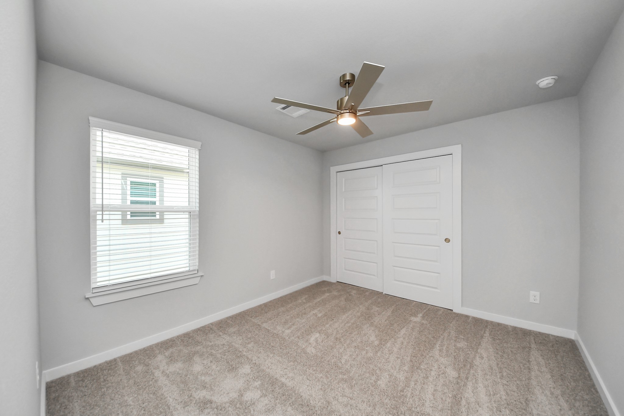 Secondary bedroom features plush carpeting, large windows that let in plenty of natural light, bright paint, and spacious closets. Sample photo of completed home with similar floor plan. Actual colors and selections may vary.