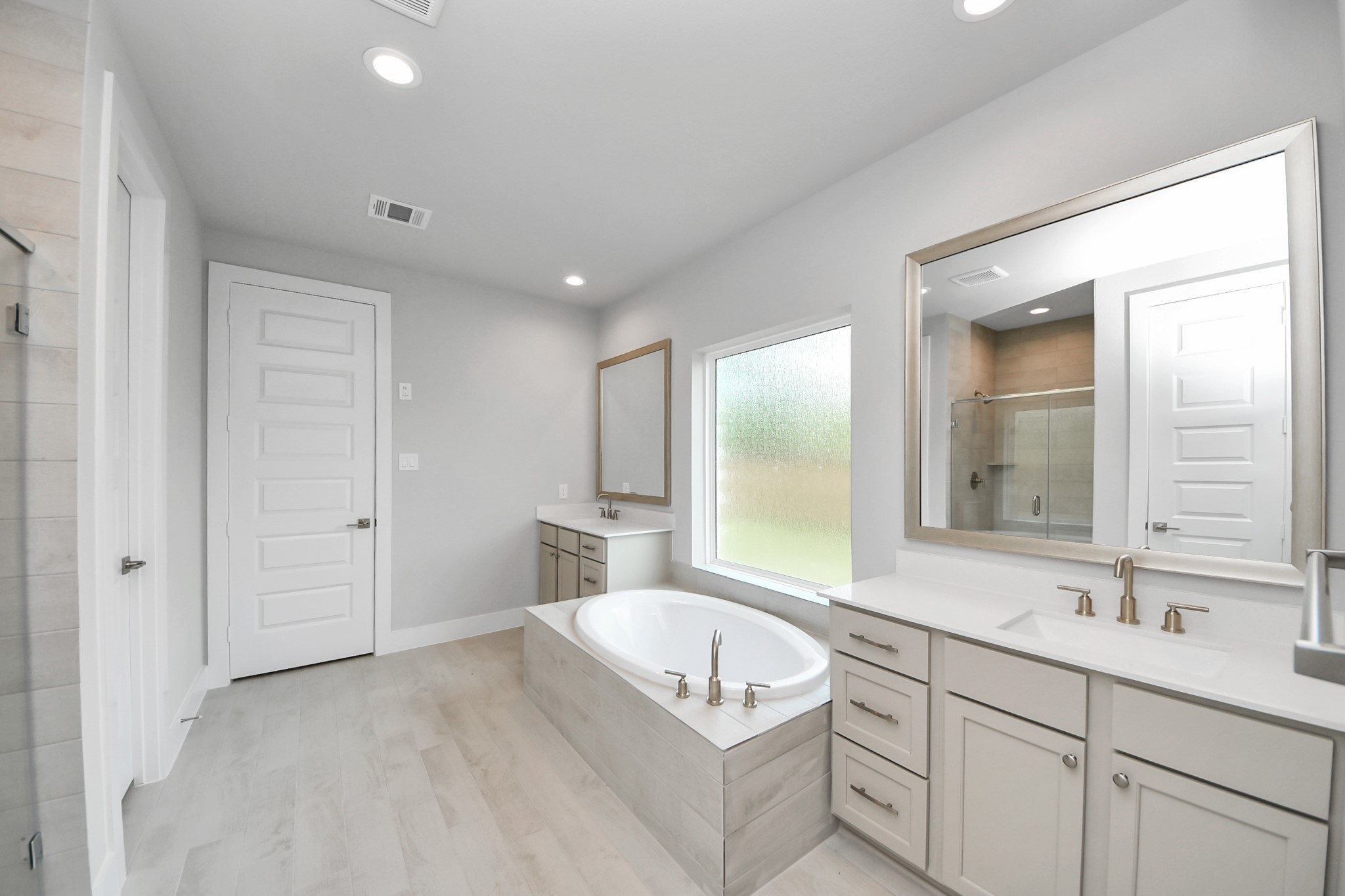 Indulge in the serenity of your primary bathroom, a true retreat designed for relaxation. The spacious walk-in shower, encased in elegant tile, invites you to unwind, while the separate garden tub, featuring unique, custom details, offers a perfect place for soaking away the day's stresses. Sample photo of completed home with similar floor plan. Actual colors and selections may vary.