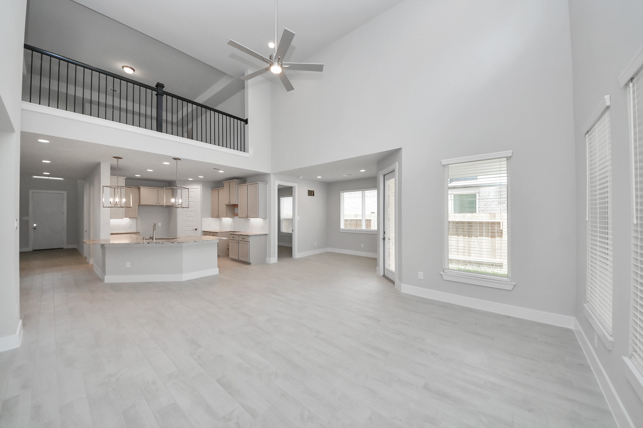 Gather the family and guests together in your lovely living room! Featuring soaring high ceilings, recessed lighting, ceiling fan, custom paint, gorgeous floors, and large windows that provide plenty of natural lighting throughout the day. Sample photo of completed home with similar floor plan. Actual colors and selections may vary.