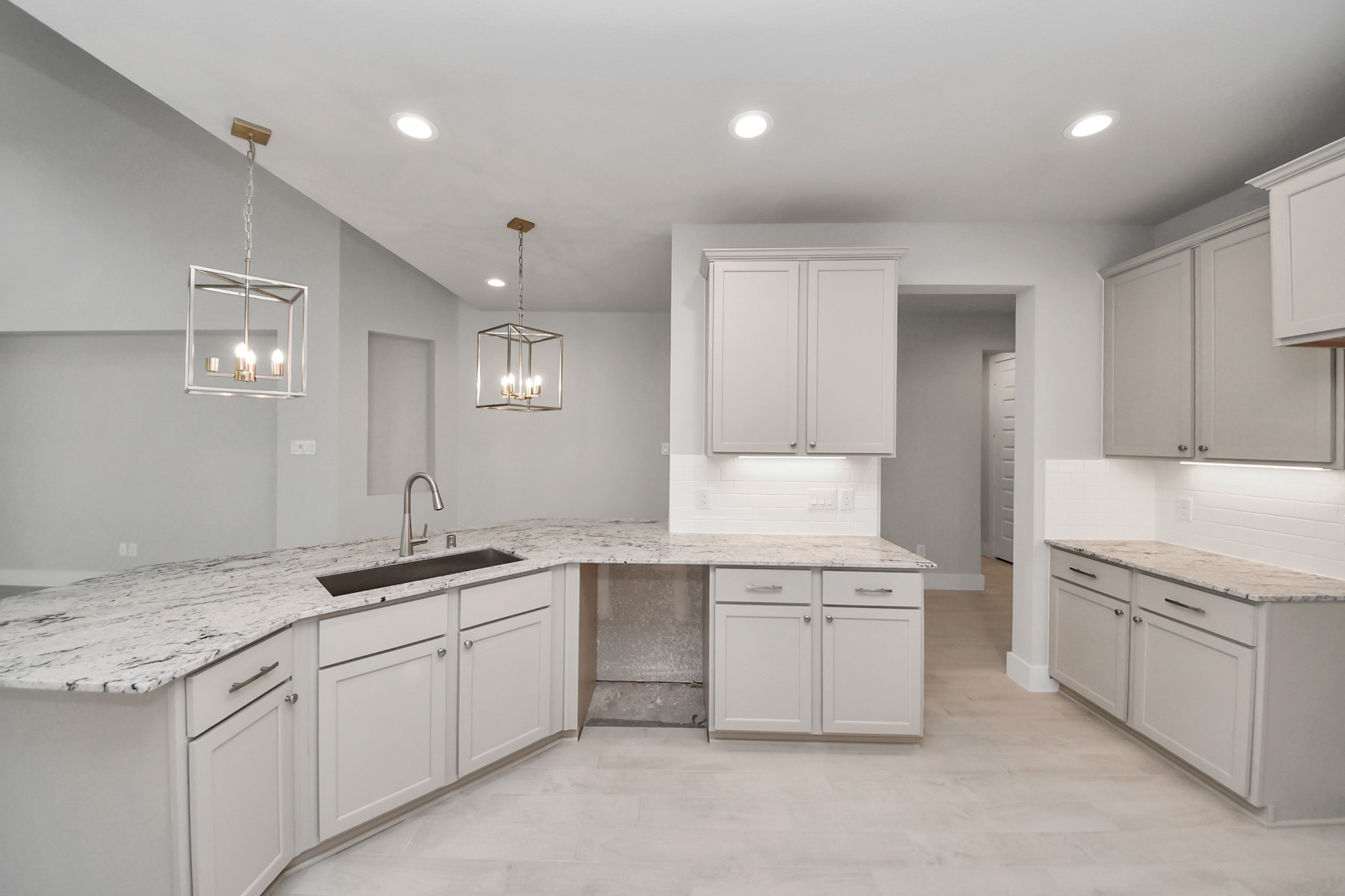 The kitchen is a culinary haven, featuring granite countertops, a tile backsplash, stainless steel appliances, 42 upper cabinets, and undercabinet lighting. Sample photo of completed home with similar floor plan. Actual colors and selections may vary.