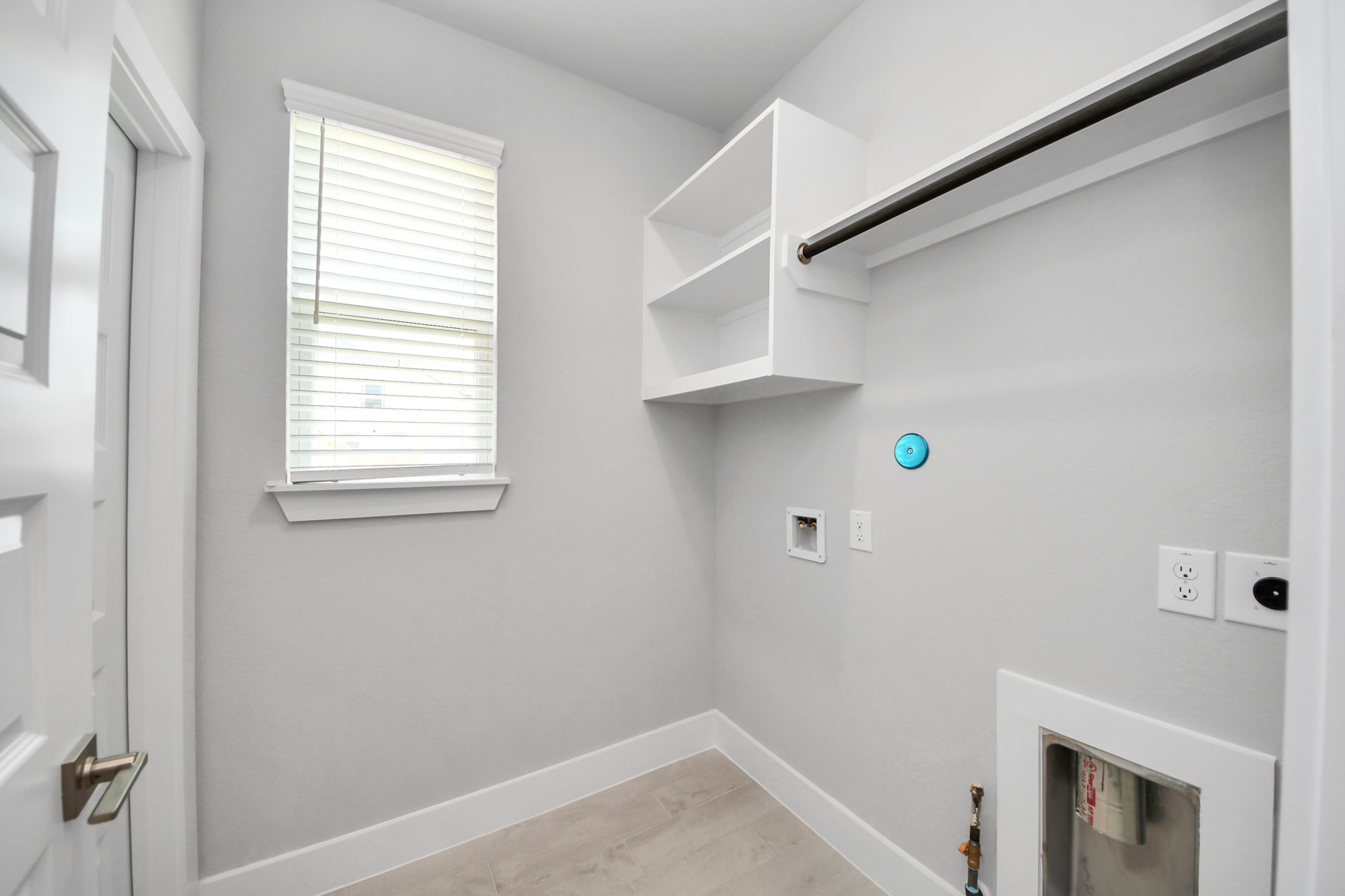 A perfect blend of functionality and comfort. Capture the essence of easy living with a first-floor laundry room, thoughtfully equipped with shelving for effortless organization. Both electric and gas connections available. Sample photo of completed home with similar floor plan. Actual colors and selections may vary.