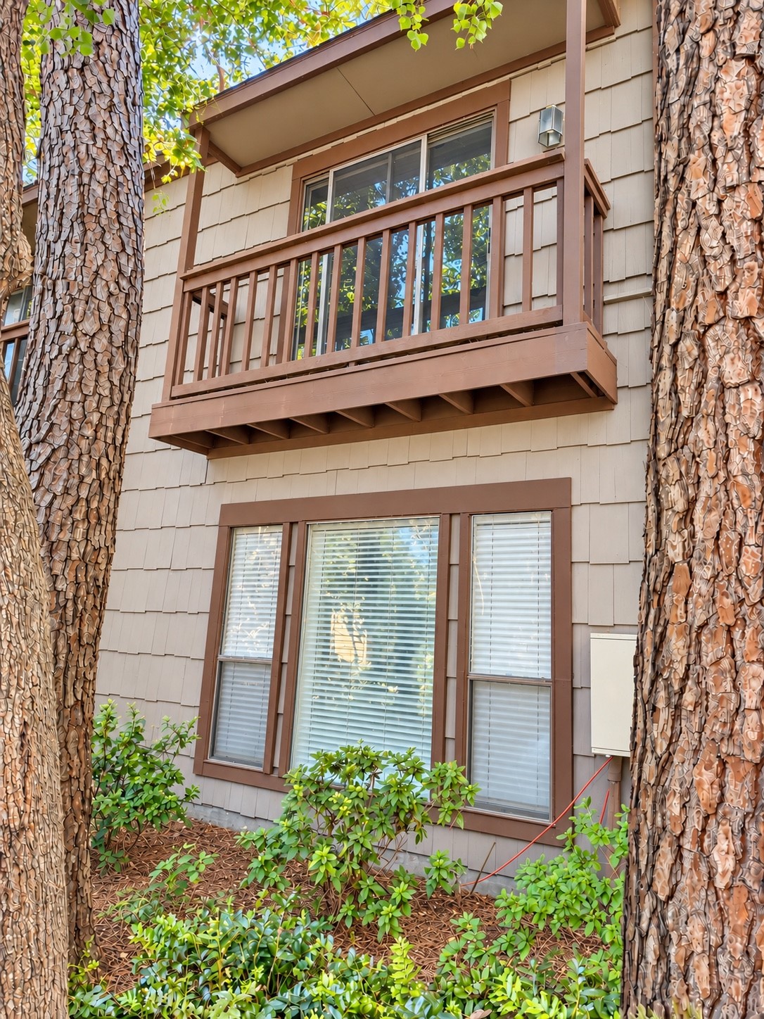 Charming Exterior with an upper covered balcony, large window beneath