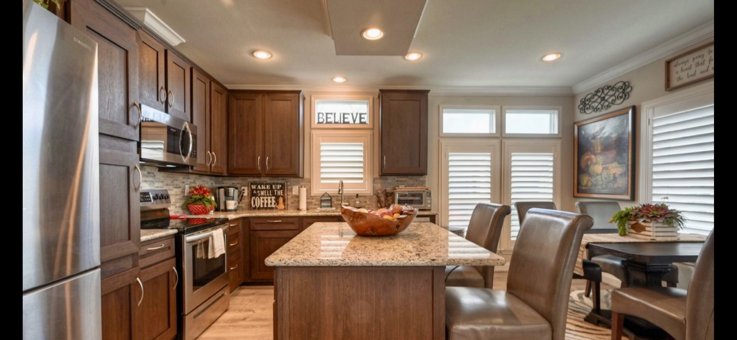 Open kitchen connects to the living area & features Frigidaire appliances, a pantry, breakfast bar & ample cabinetry. Refrigerator included.