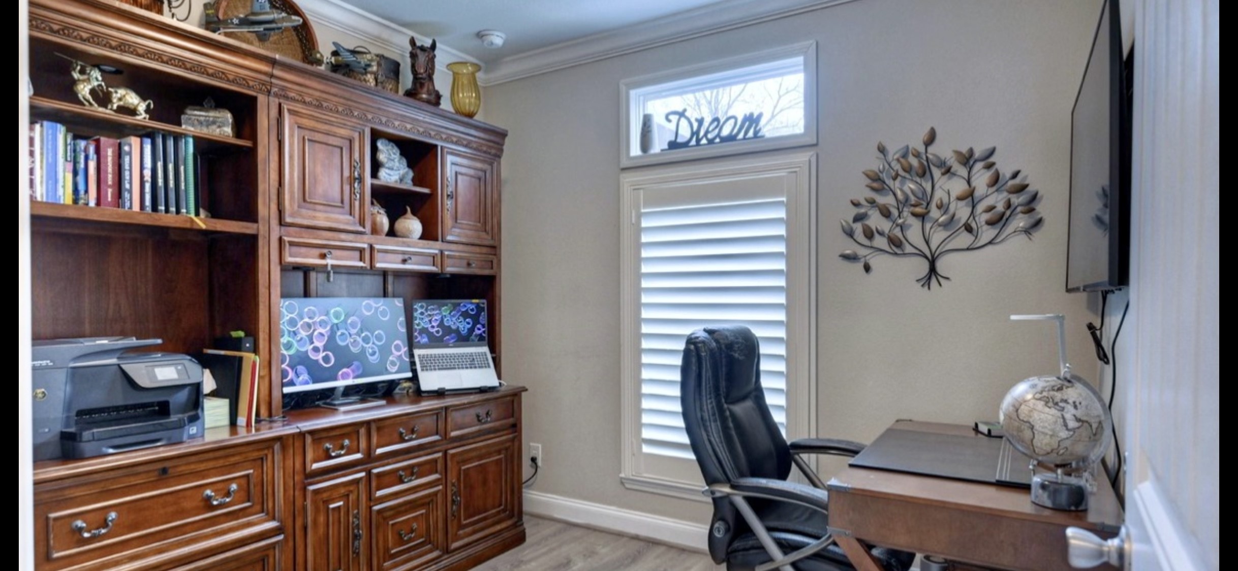 Another view of the secondary bedroom highlights its versatility, shown with a desk & shelving for a home office setup.