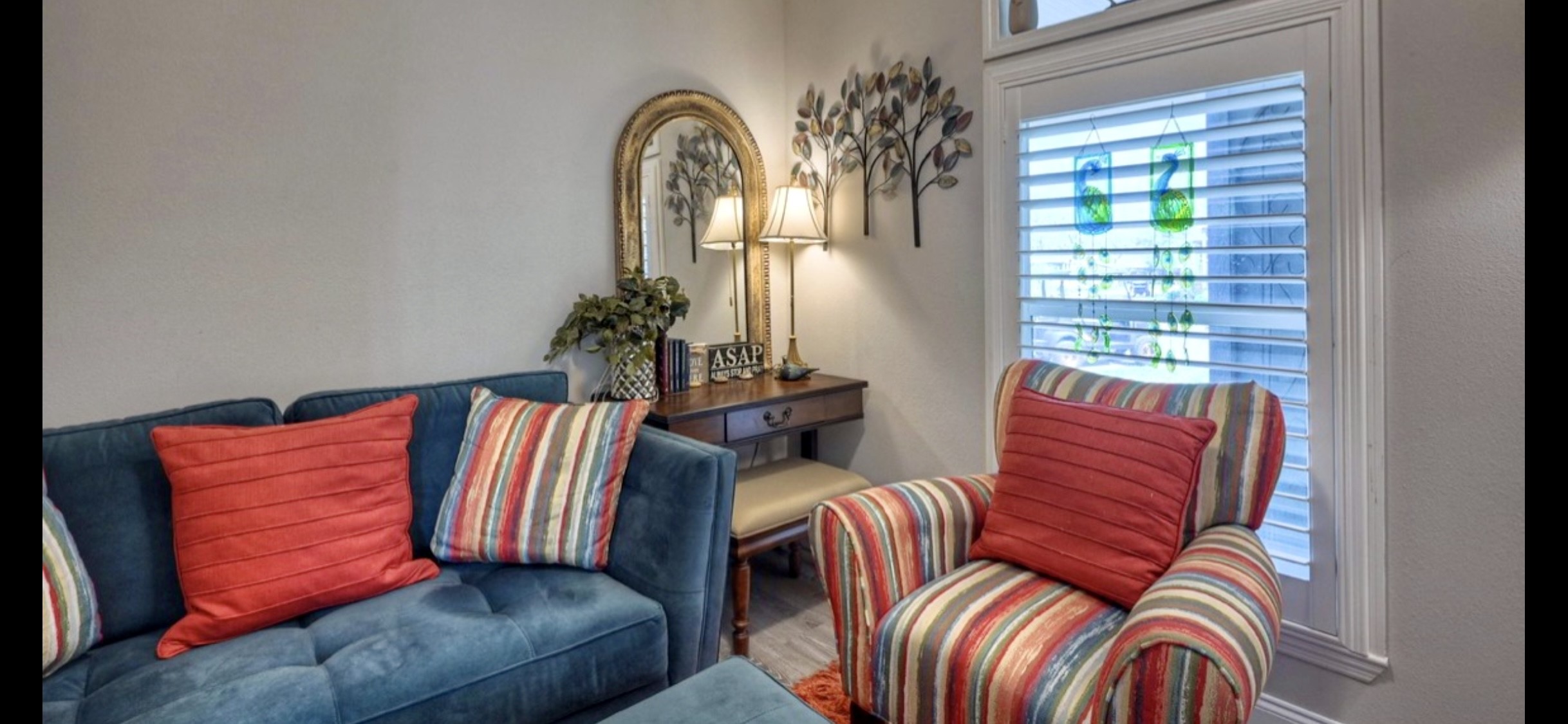 Secondary bedroom offers flexible space for guests or hobbies, with a ceiling fan & shuttered window.