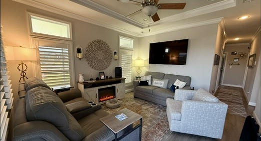 Inviting living room features a tray ceiling, crown molding, transom windows & upgraded flooring. TV & TV mounts are included.