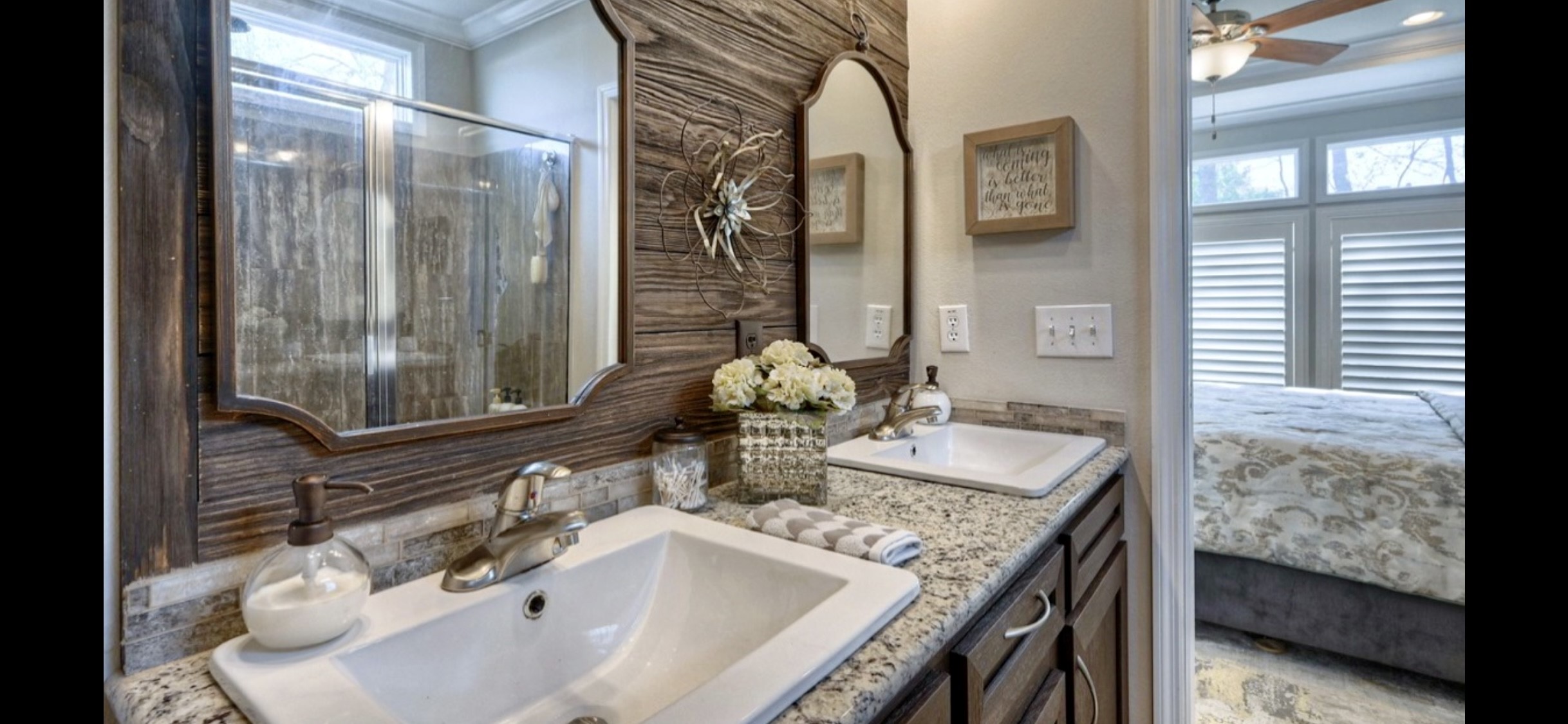 Primary bath offers double sinks, generous vanity storage & natural light through a shuttered window.