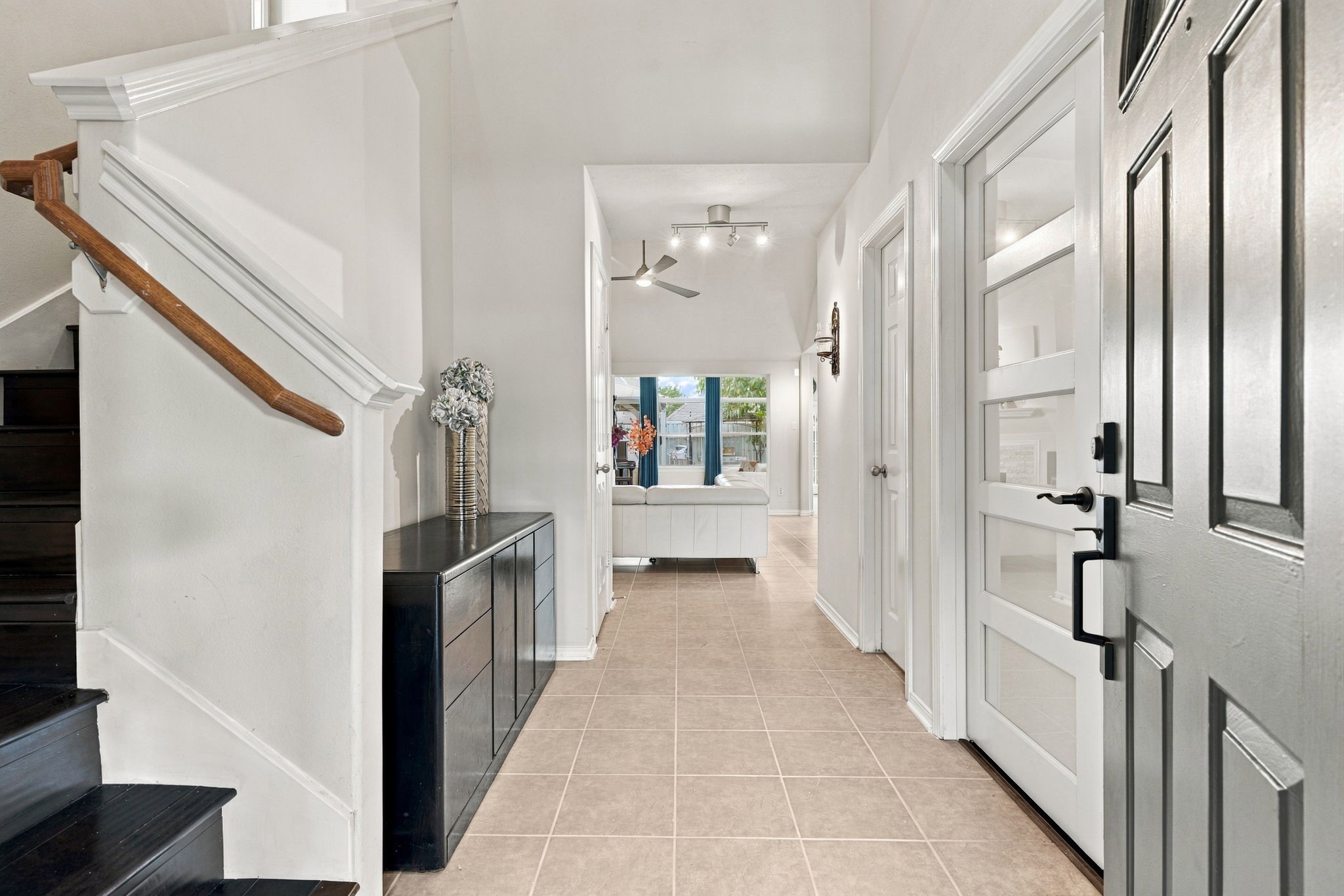 Bright and inviting entryway features sleek tile flooring and modern design, leading to an open living area.