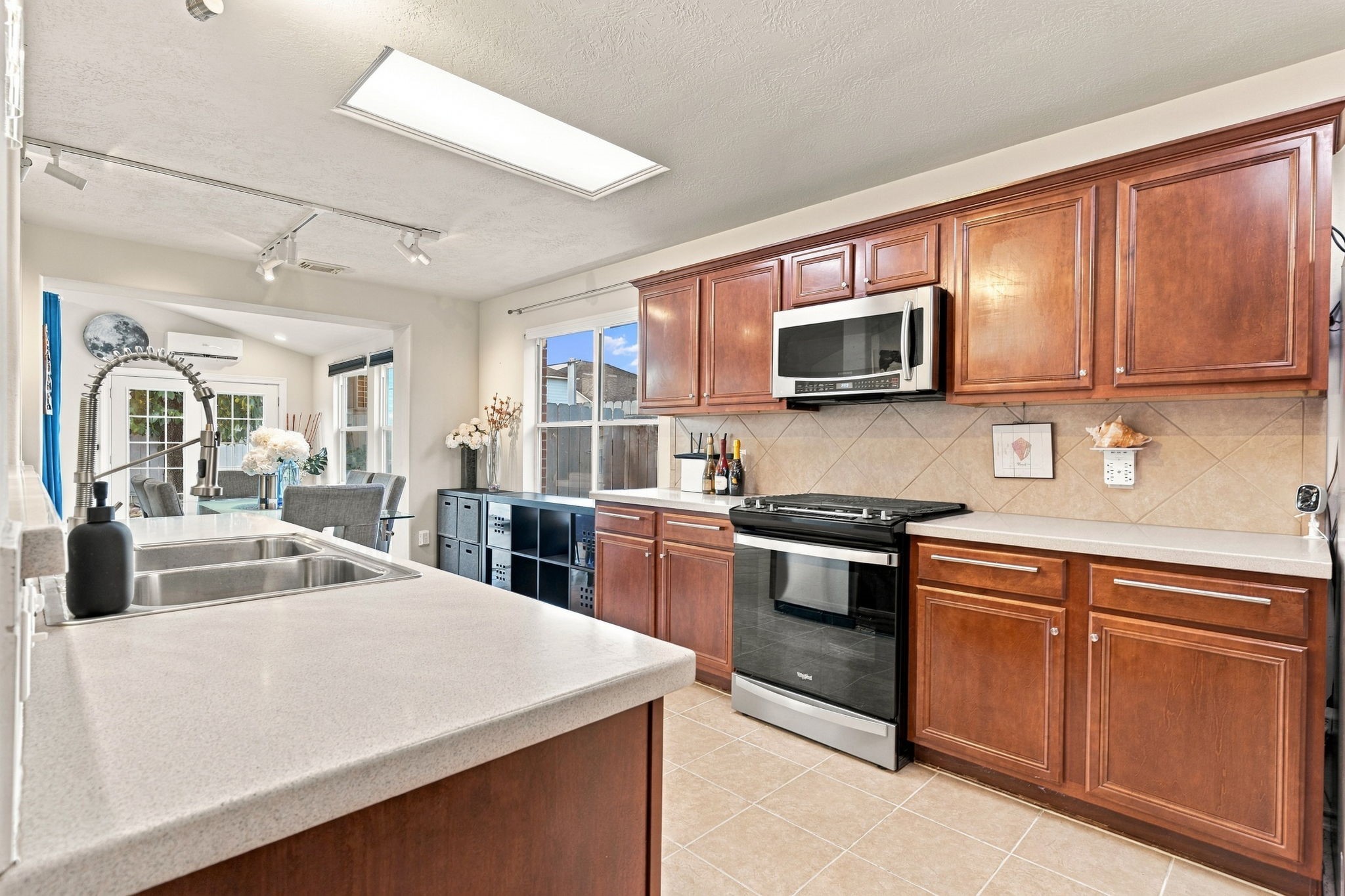 Spacious kitchen with rich wooden cabinetry, modern stainless steel appliances, and a cozy dining area filled with natural light.