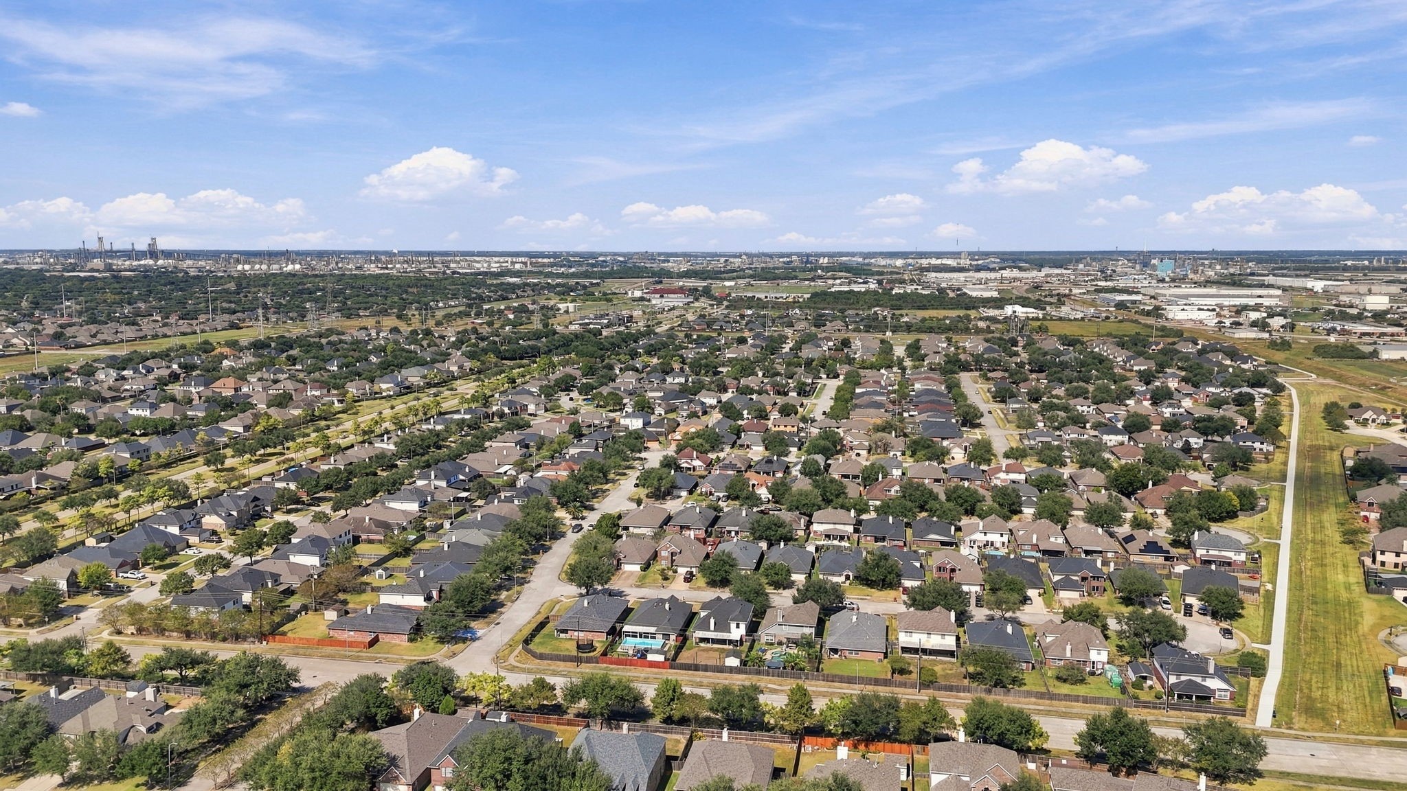 Expansive suburban neighborhood with neatly arranged homes, tree-lined streets, and open sky, offering a sense of community and tranquility.