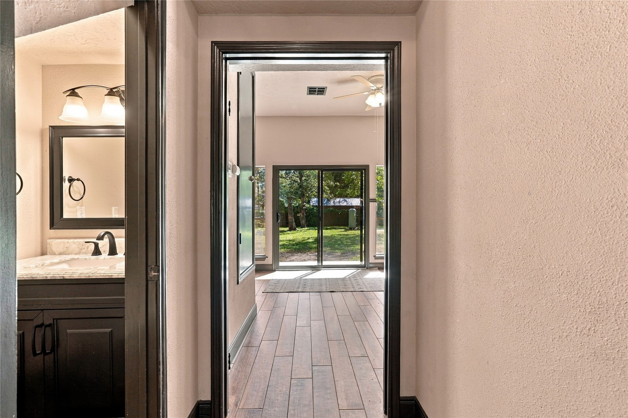 View from the front entry down the hallway, with convenient access to the half bath on the left and breakfast room overlooking the backyard.