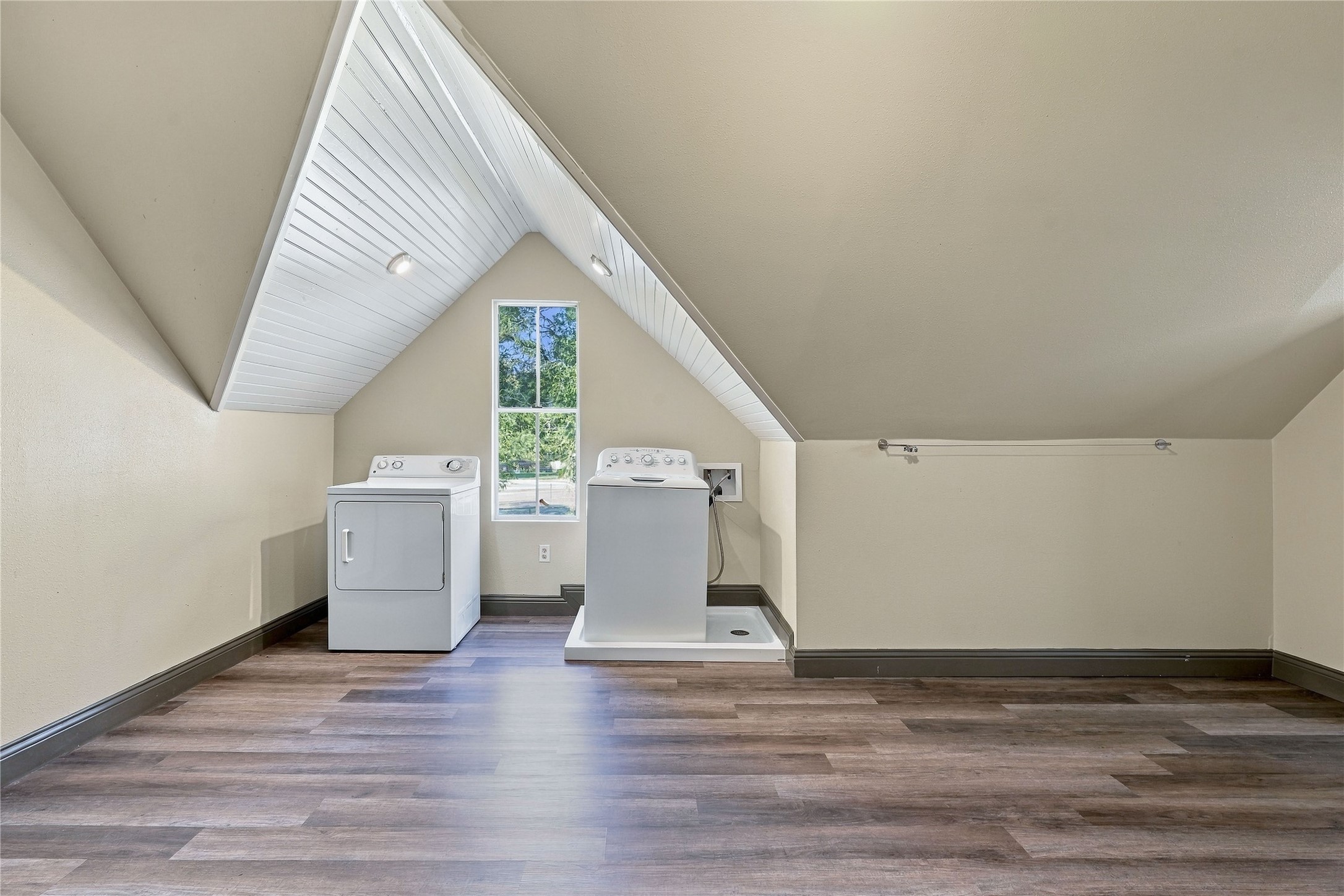 Upstairs laundry and bonus room featuring washer and dryer connections, natural light, and generous additional floor space.