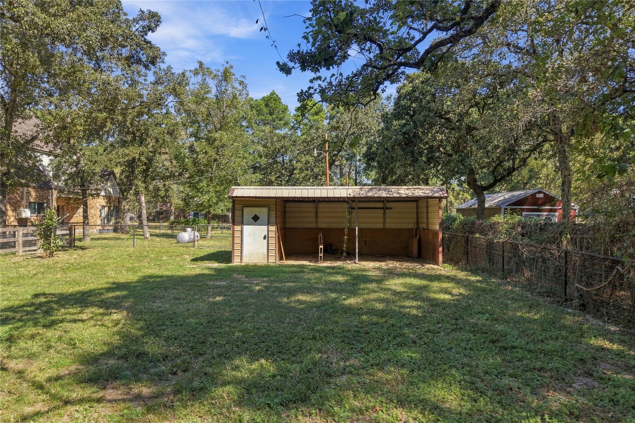 Horse stall with covered bays and enclosed storage space, offering added functionality for the property.