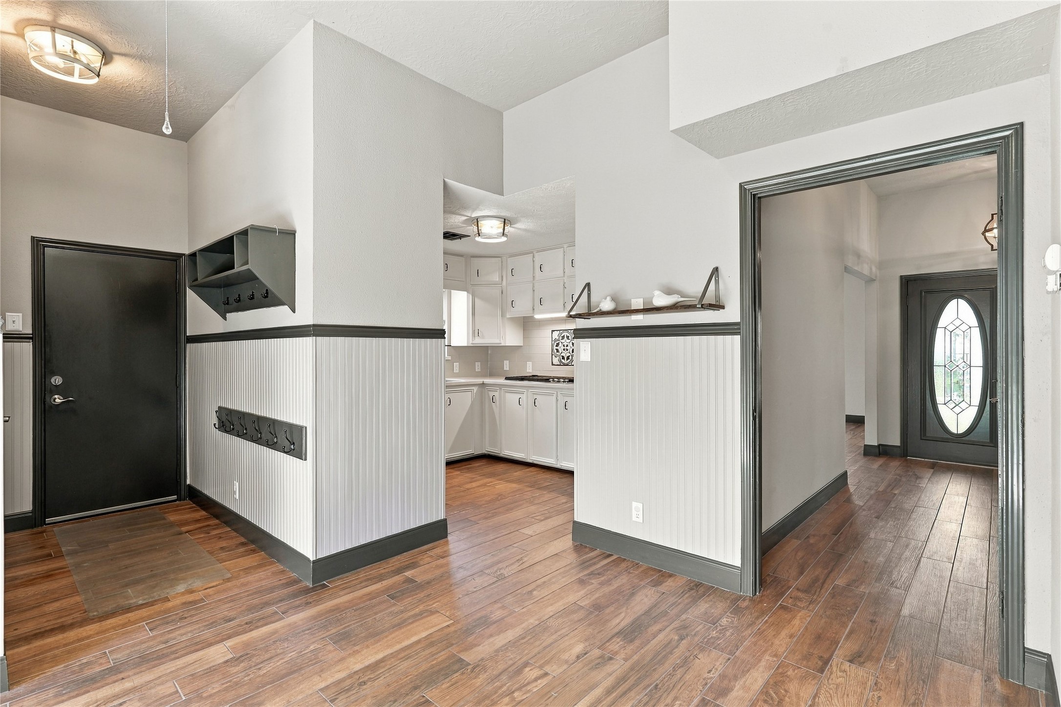 View of the breakfast area and kitchen highlighting the convenient layout, decorative trim, built-in storage hooks, and easy access to the front entry.