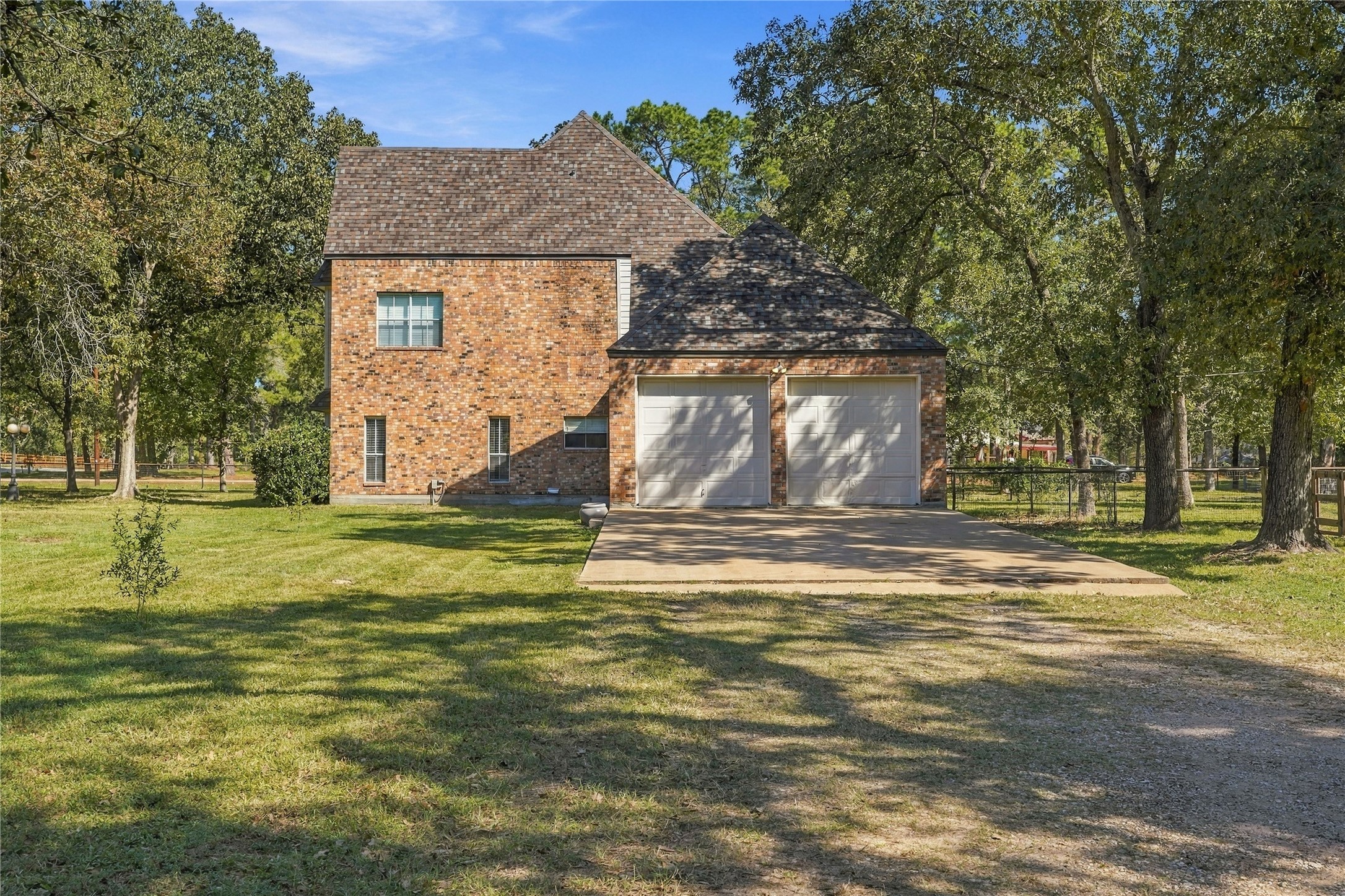 Attached two-car oversized garage with concrete parking area and convenient access from the gravel driveway.