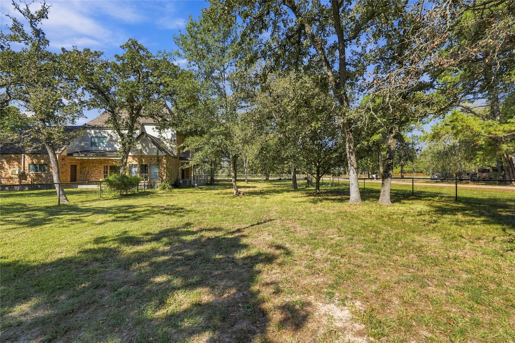 Expansive side yard with mature shade trees, fencing, and plenty of open green space to enjoy.