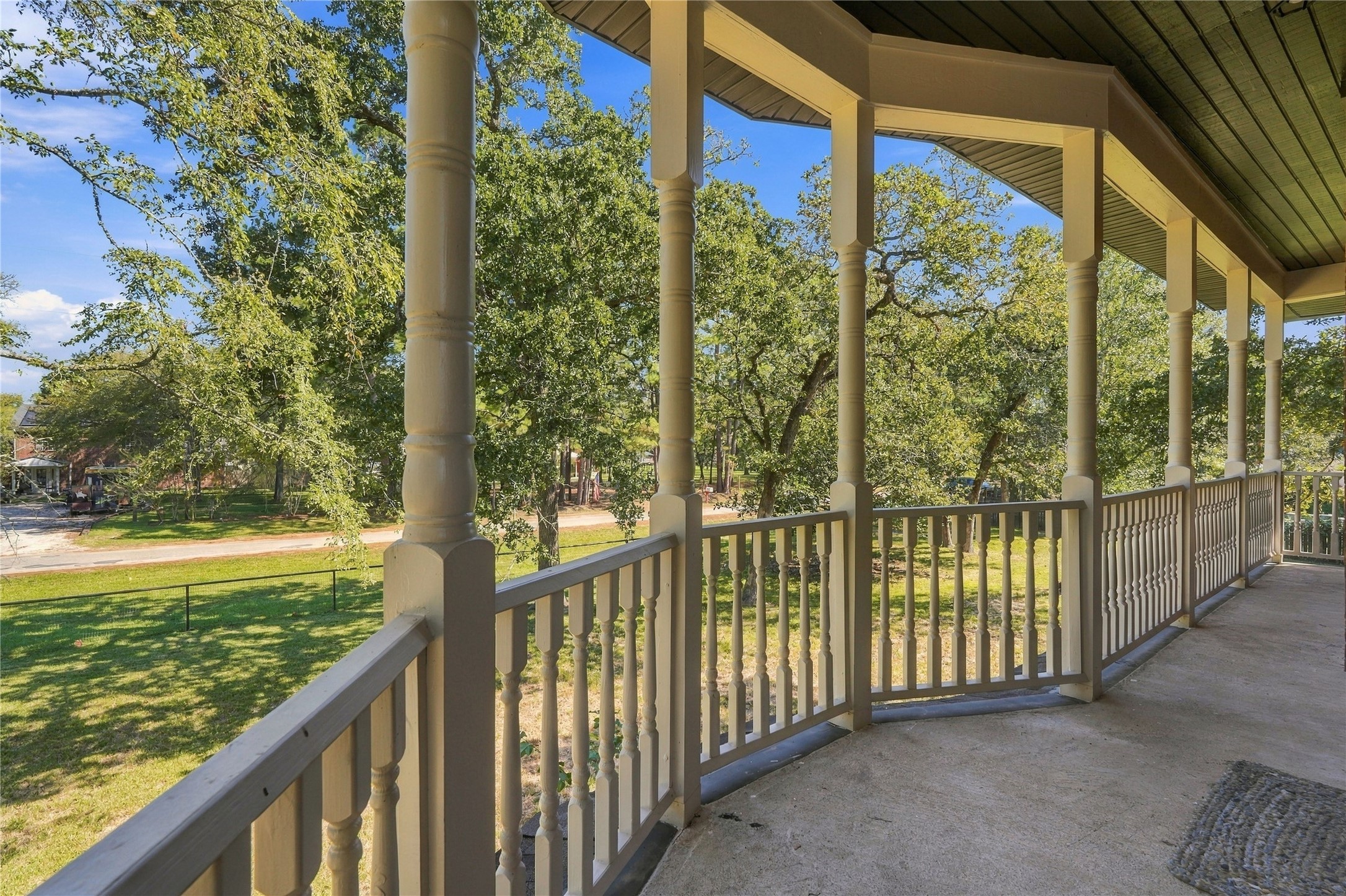 Additional balcony view showcasing the generous outdoor space and scenic, tree-lined surroundings.
