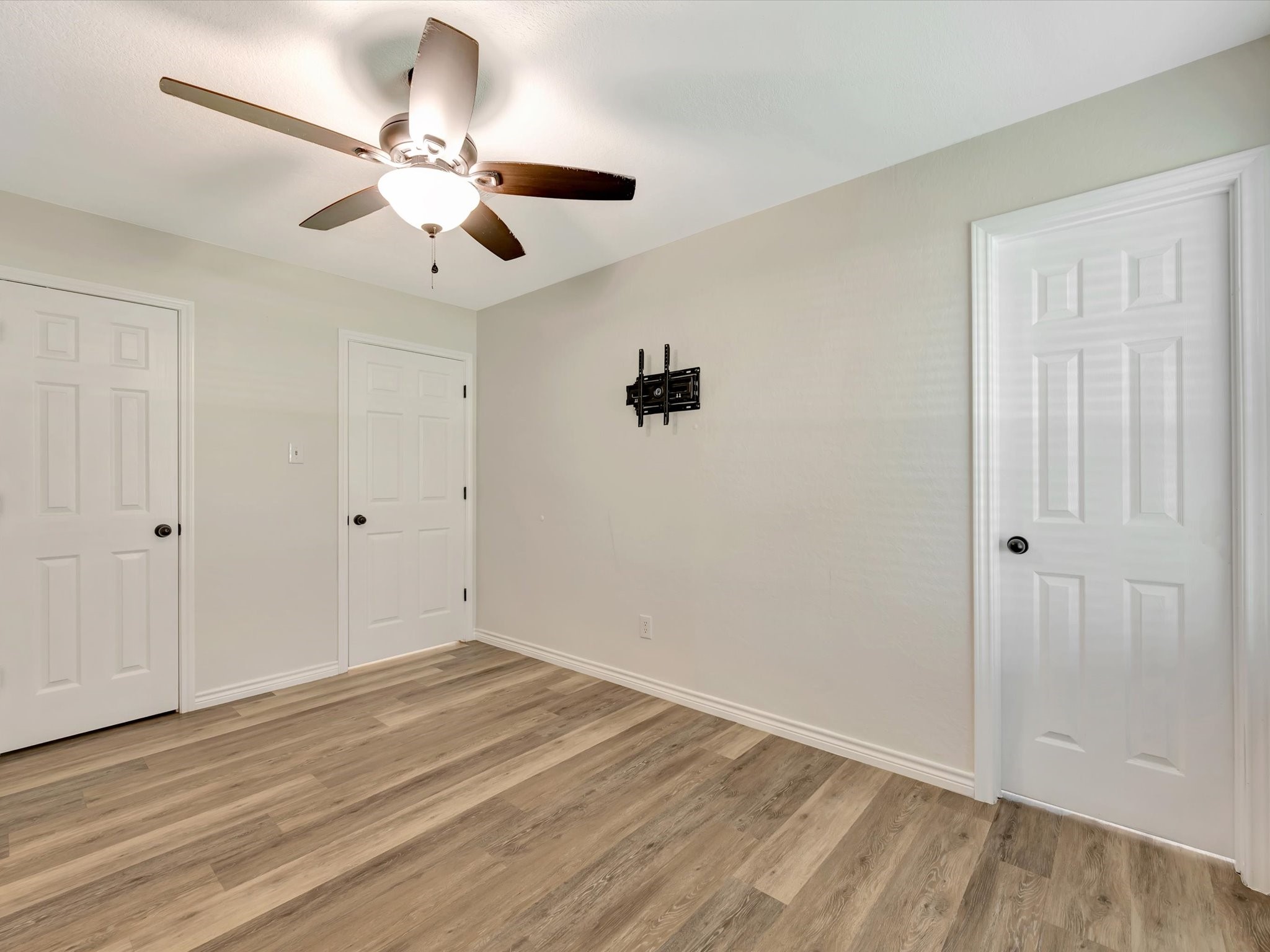 Primary bedroom suite featuring a ceiling fan and ample natural light.