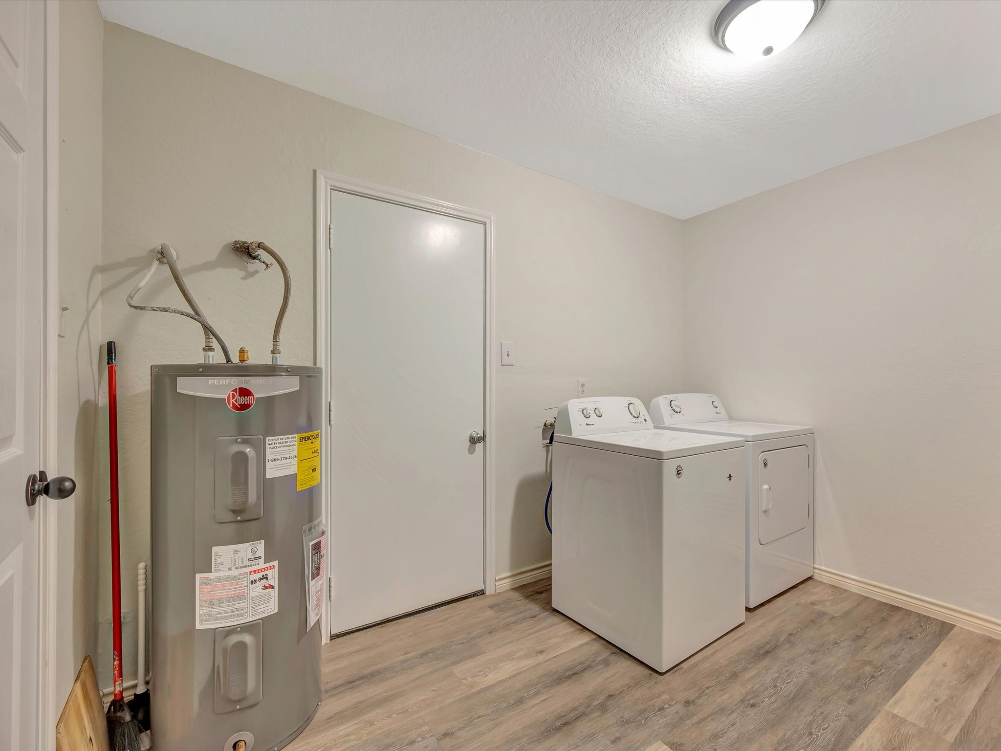 Utility room with laundry hookups and storage space.