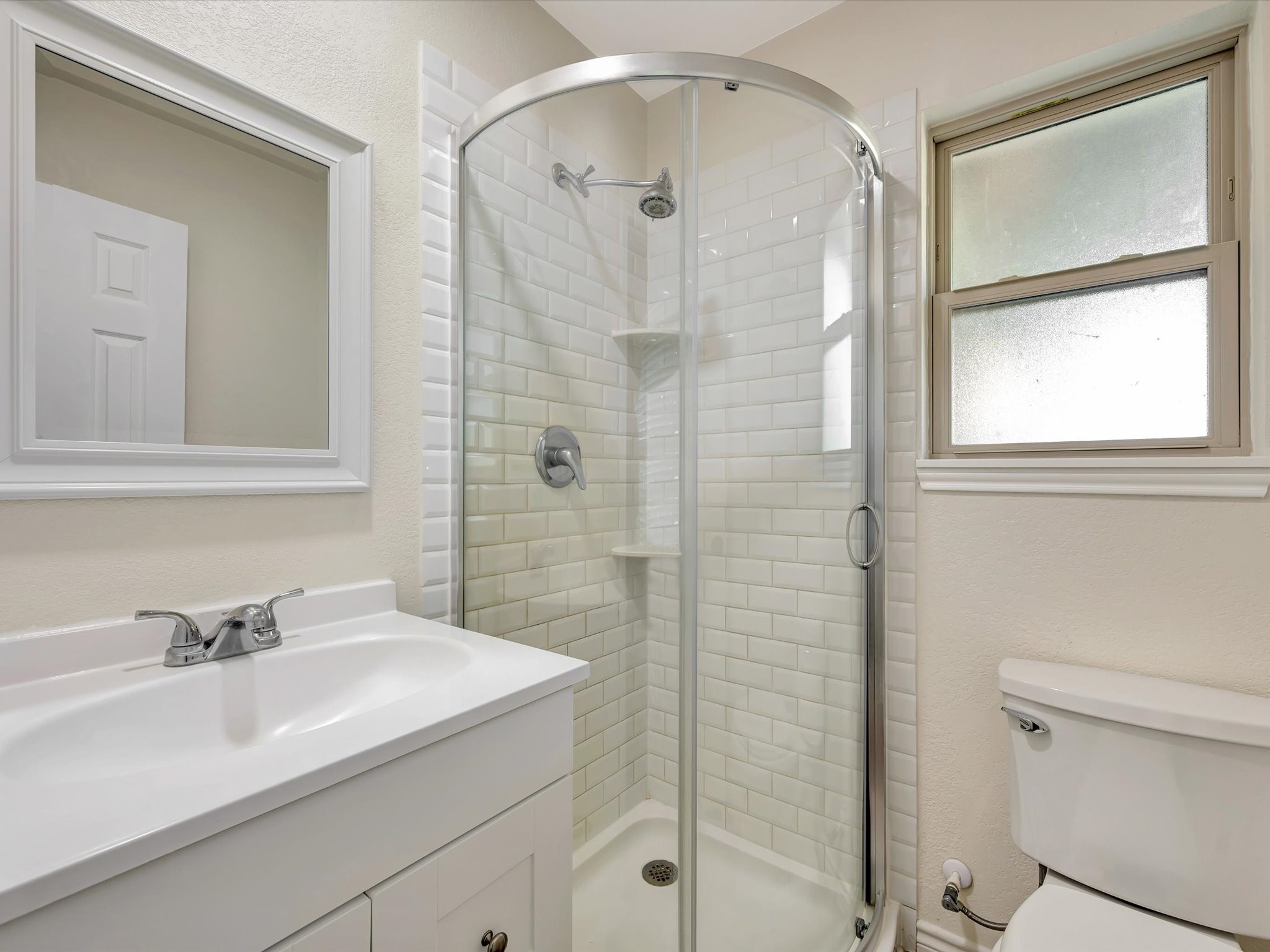Primary suite bathroom featuring a glass-enclosed shower.