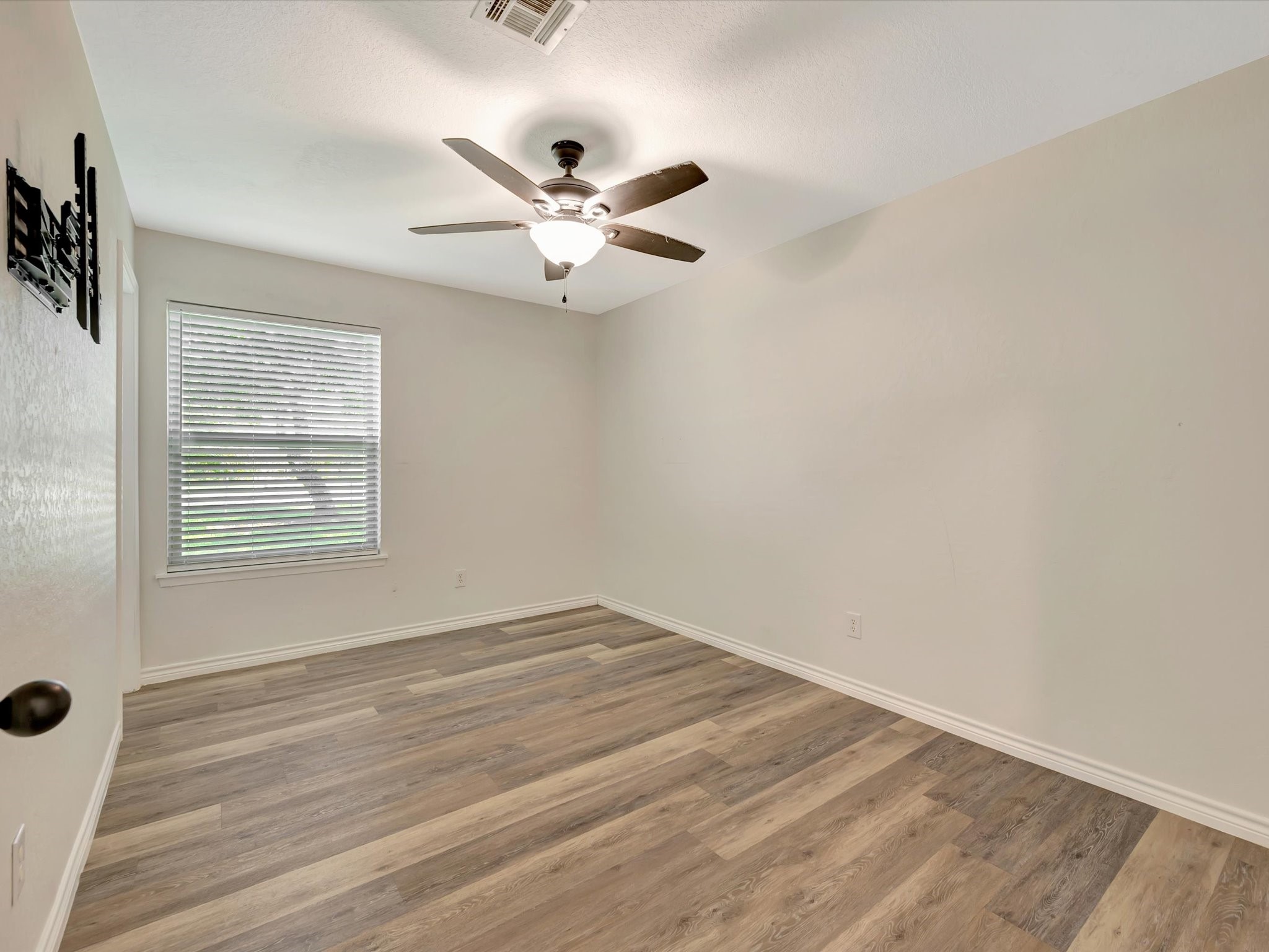 Primary bedroom suite featuring a ceiling fan and ample natural light.