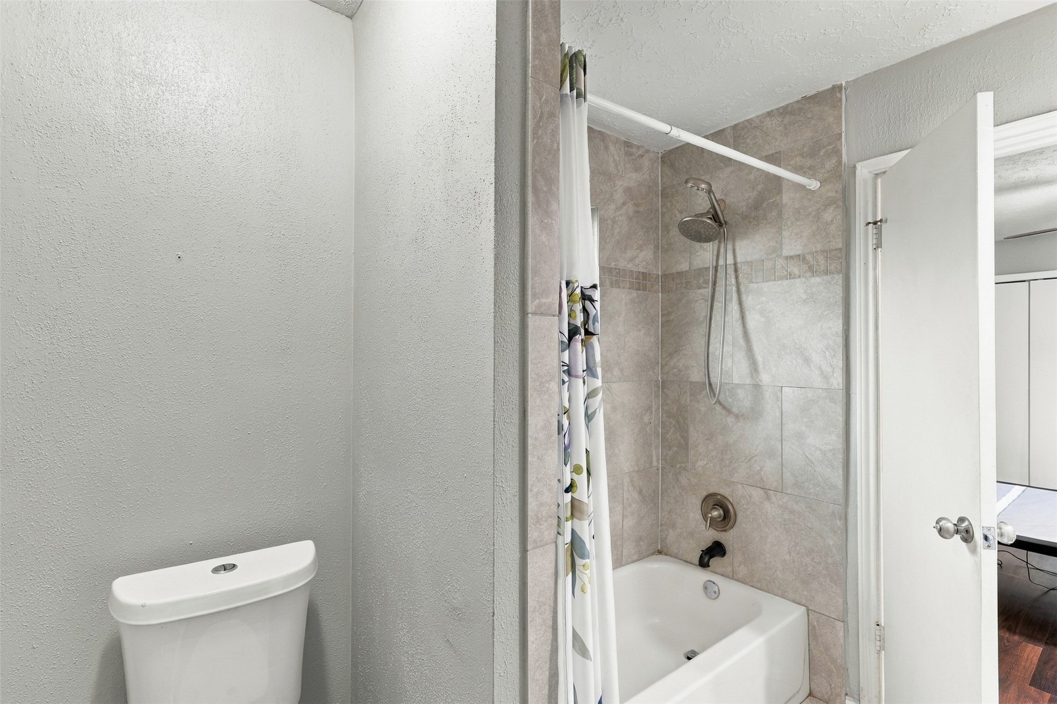 An additional bathroom view highlights the tub/shower combination and tiled surround.