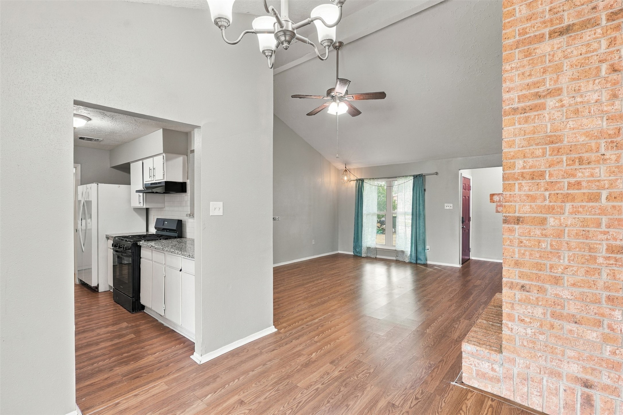 Conveniently positioned dining area connects the kitchen and living room, with the brick fireplace adding warmth and character.