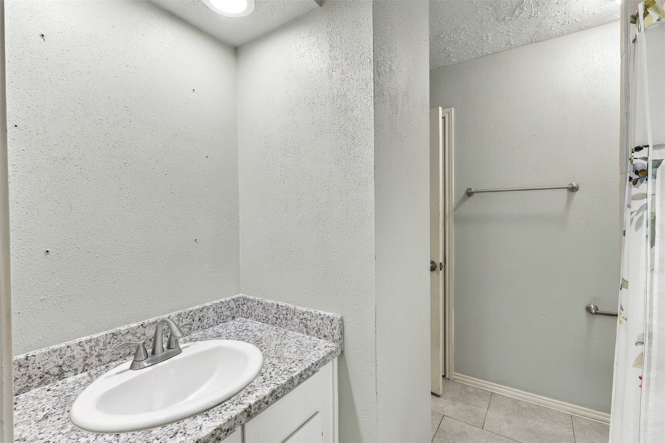 Bathroom features a granite-topped vanity, a new mirror will be installed, and a tub/shower combination.