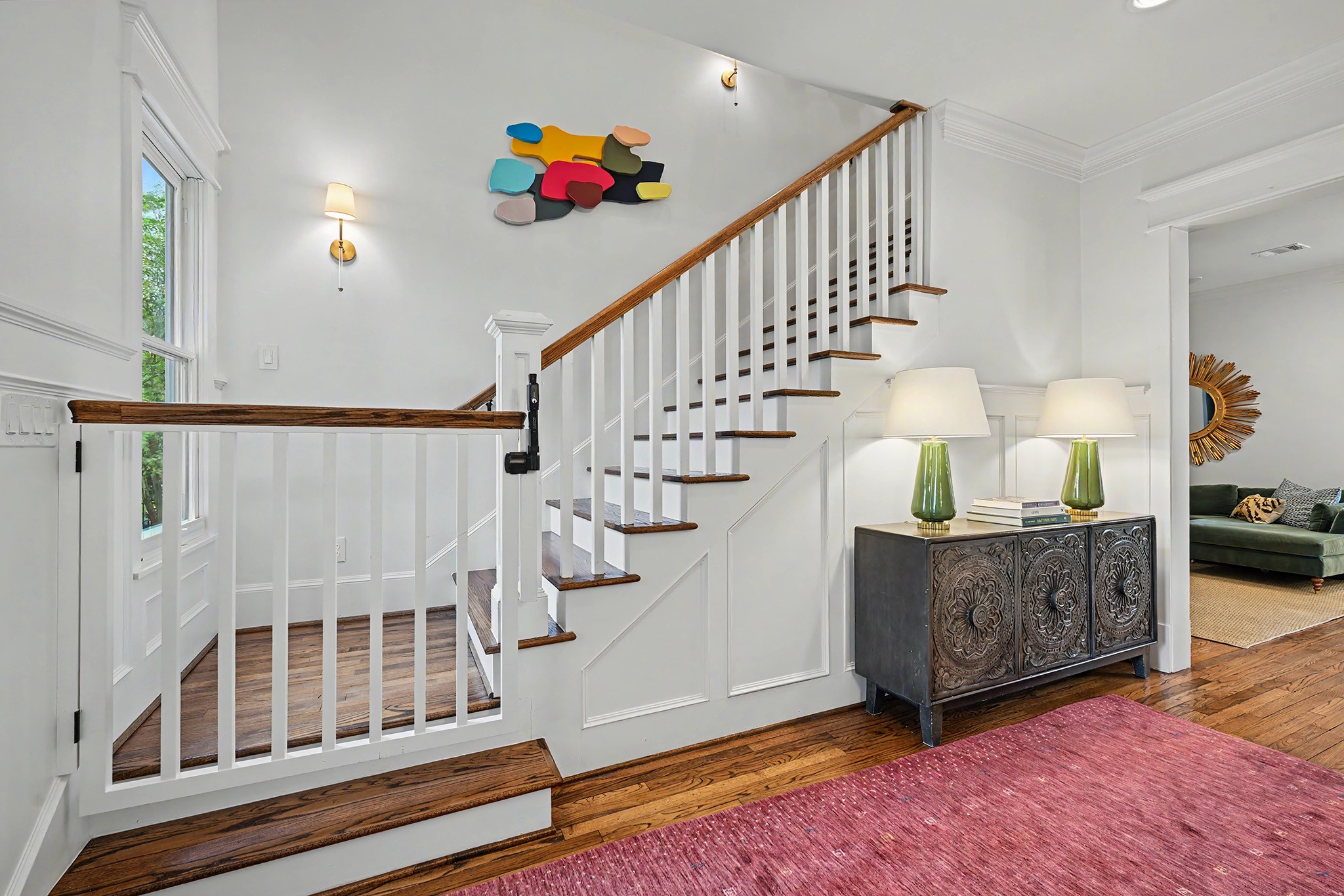 Fabulous staircase with light sconces along with a kid/dog gate. There's also safety gate at the top of the stairs. One other cool feature is a secret door just to the left of the console piece that's perfect as an extra play spot or for storage.