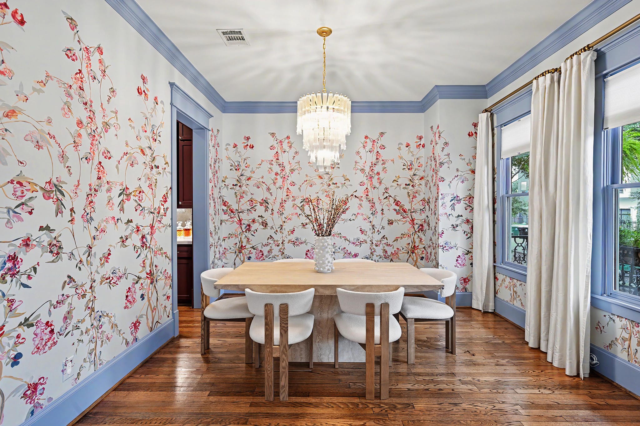 A second look at the dining room that is highlighted by wallpaper of hand-painted panels designed specifically for the space.