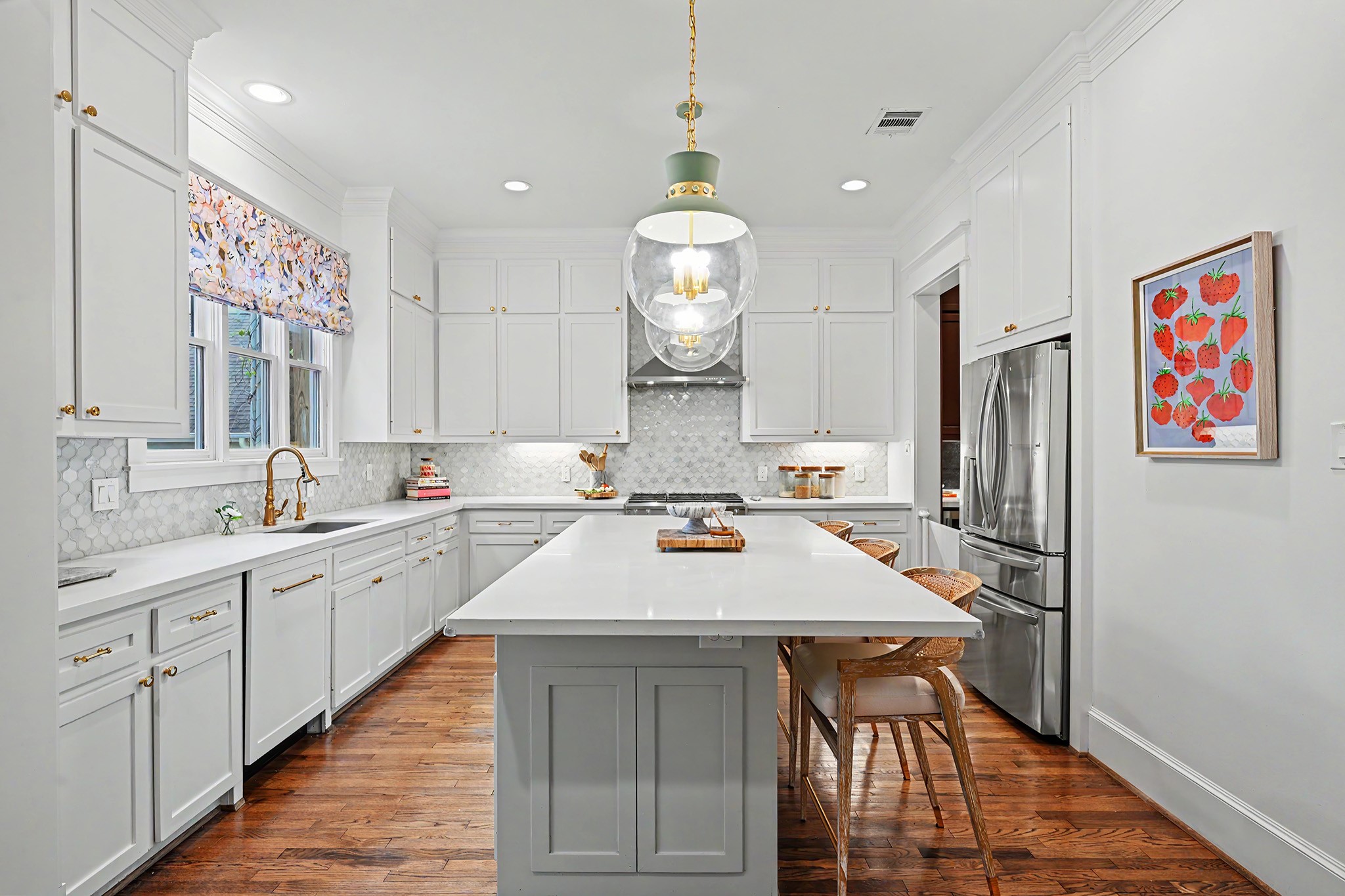 A true gourmet kitchen offers quartz counters, stainless steel appliances, island with counter seating and abundant cabinet space.