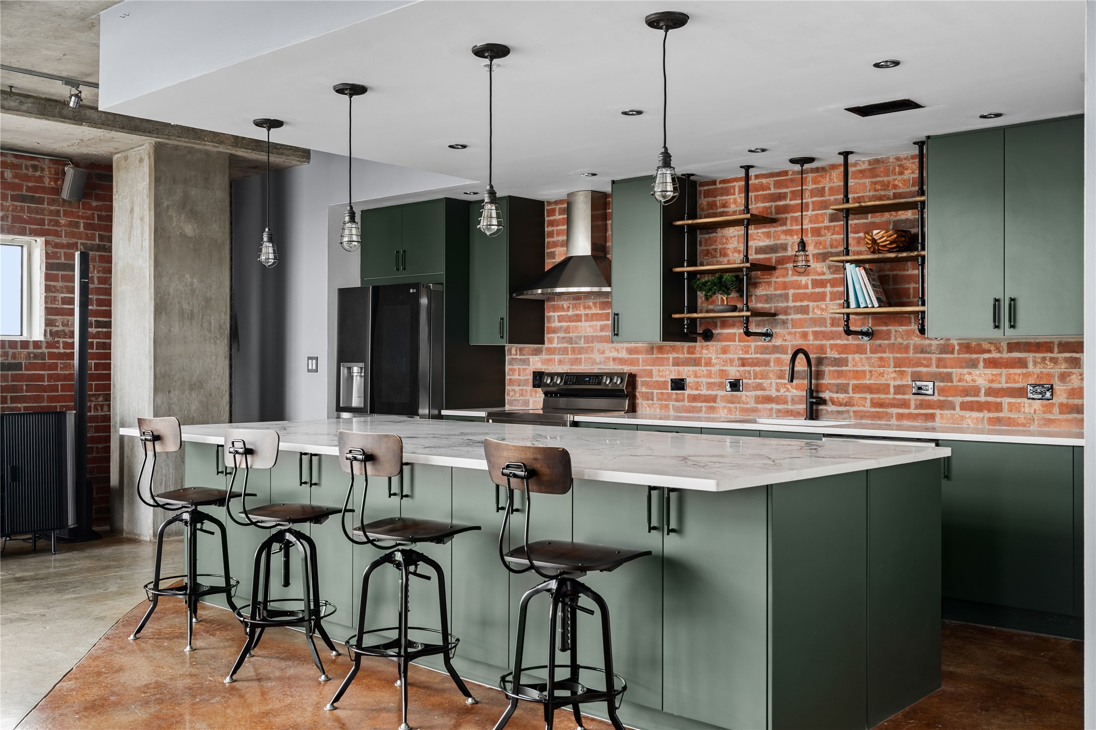 The completely renovated kitchen becomes a striking centerpiece of the loft, pairing custom cabinetry, an oversized island and modern finishes with the warmth of the original exposed brick backdrop.