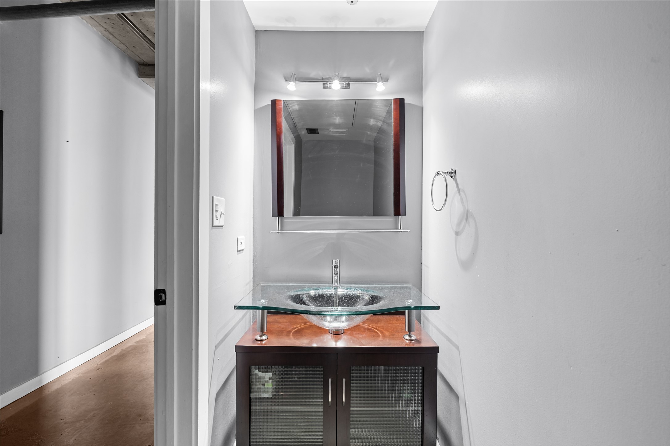 A stylish powder room adds personality just off the main living spaces, pairing a modern vanity with the lofts clean, contemporary aesthetic.