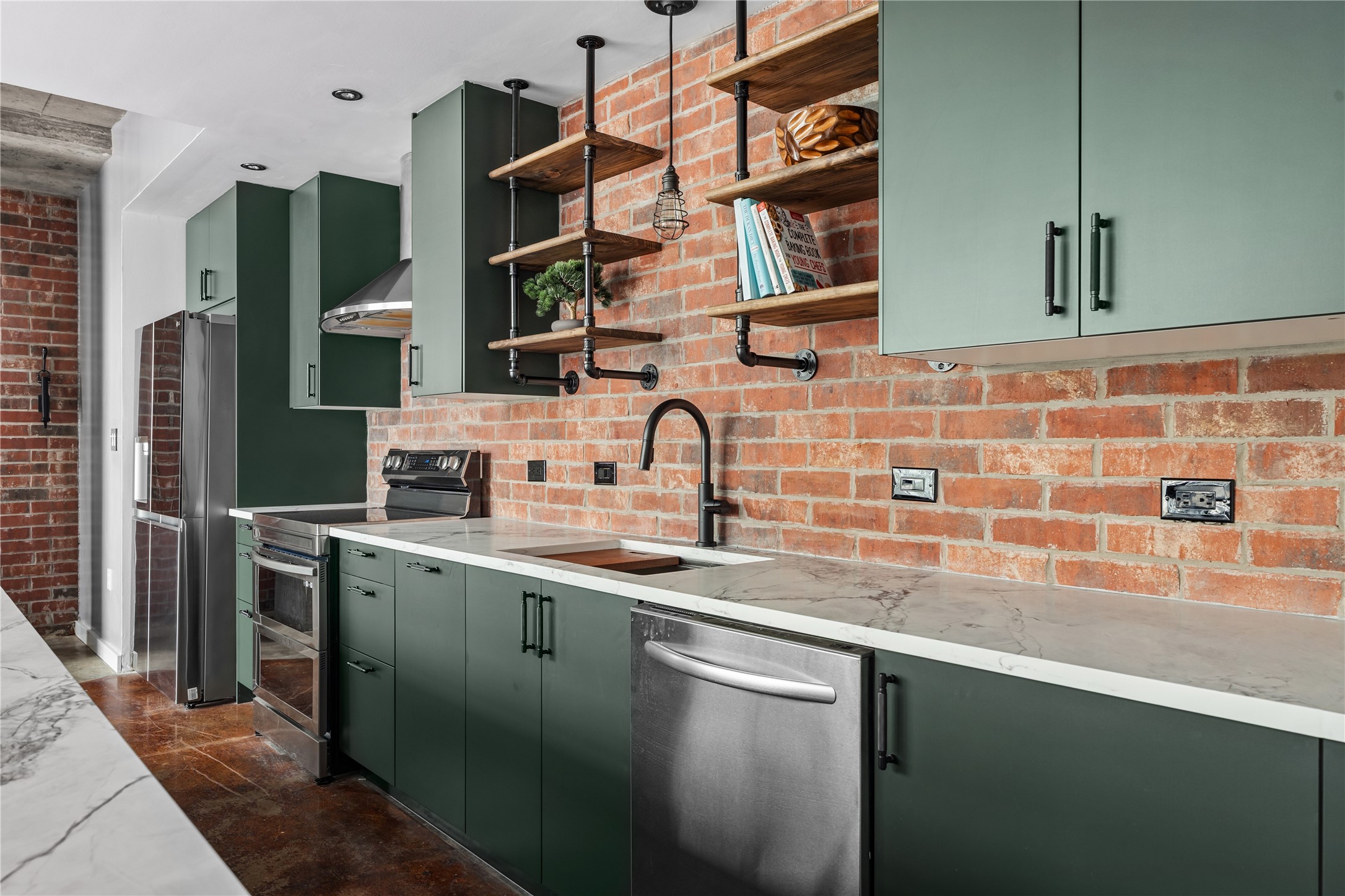 A closer view highlights the kitchens thoughtful renovation, where rich cabinetry and modern appliances are set against exposed brick for a refined take on authentic loft living.