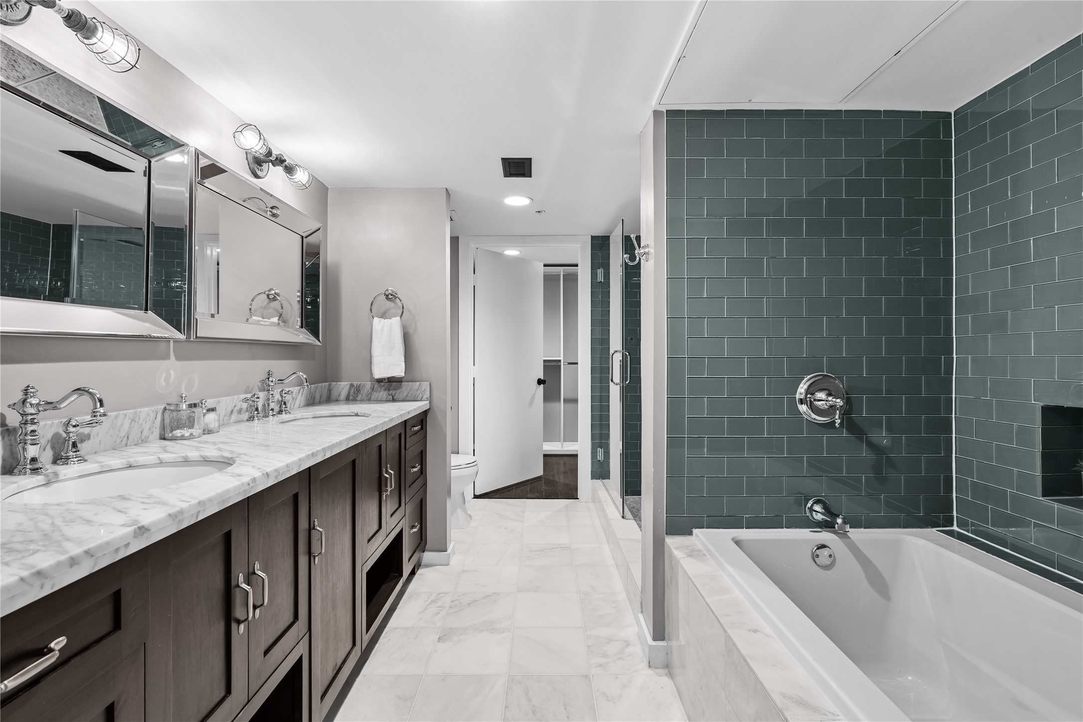 The remodeled primary bath continues with an oversized glass enclosed shower, designer tile and a separate soaking tub, creating a clean, contemporary retreat.