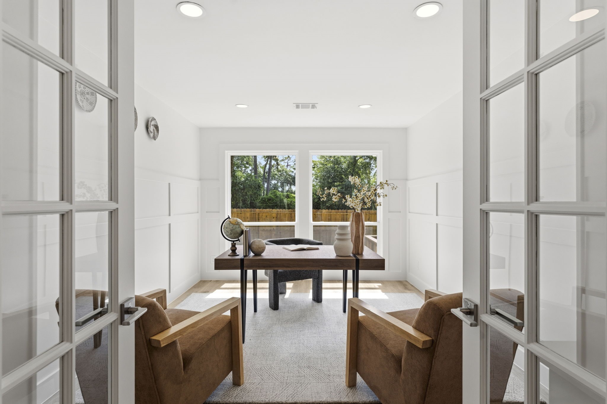 Behind elegant French doors, the private study offers the perfect space for a home office, library, or flex room. Custom wood accent walls add warmth and character, while abundant natural light creates a bright and inspiring workspace that's as functional as it is beautiful.
