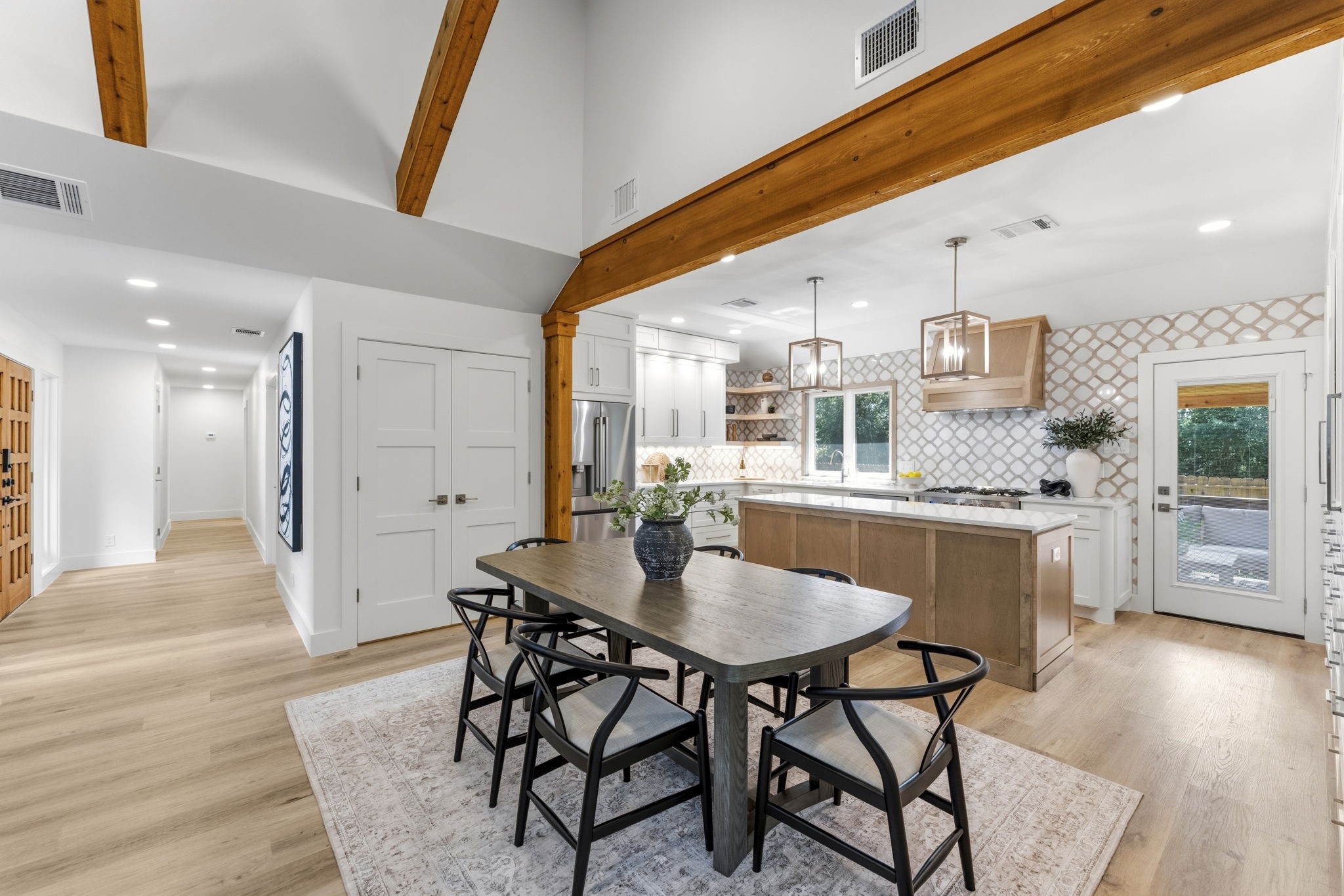 One of the home's most impressive transformations is the raised kitchen ceiling, beautifully accented with exposed cedar beams that draw the eye upward.
