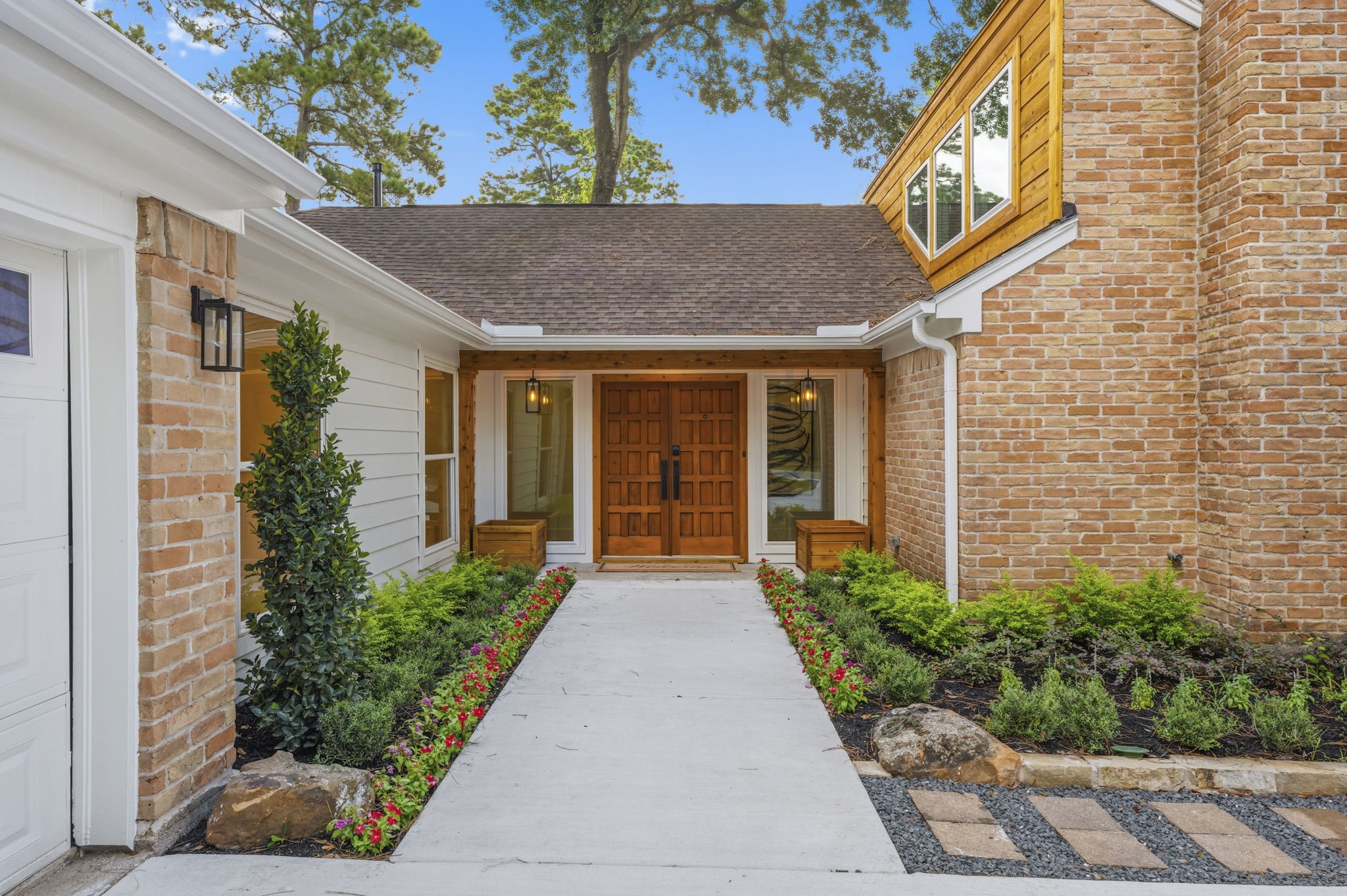 Framed by updated cedar accents, oversized sidelights, and stylish designer lighting, the inviting covered entry creates a warm first impression and showcases the exceptional attention to detail found throughout the home.