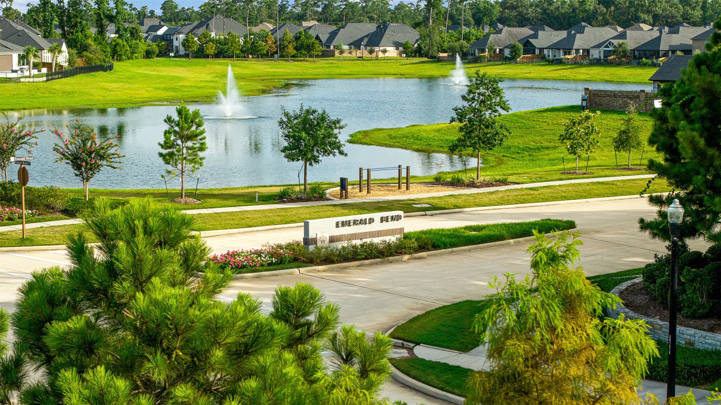 Fountains dance in the serene catch-and-release pond, surrounded by lush green space and scenic walking paths within this amenity-rich neighborhood.