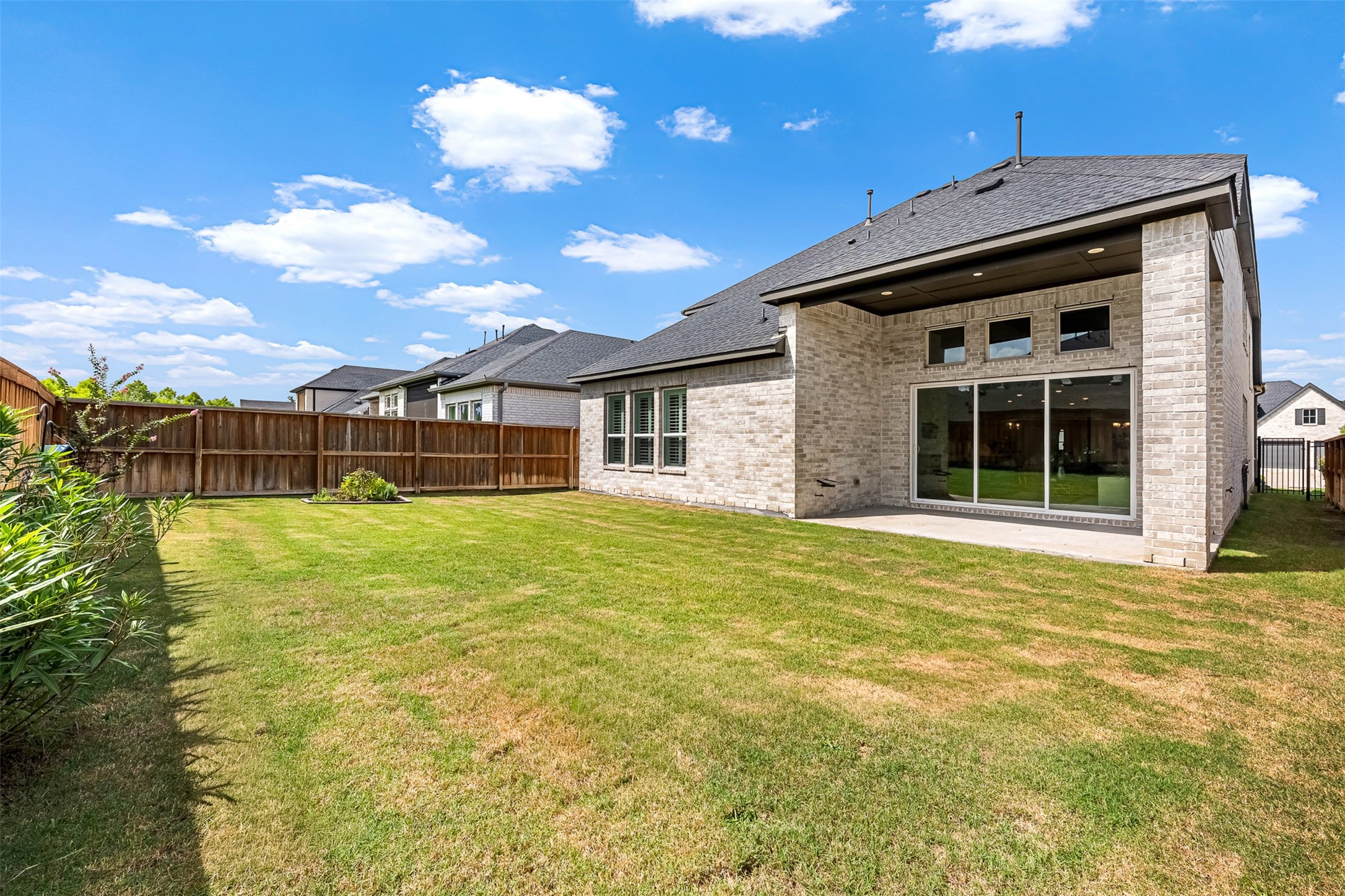 A private fenced yard offers a sprawling green space and a covered patio, creating a wonderful setting for outdoor dining and recreation.