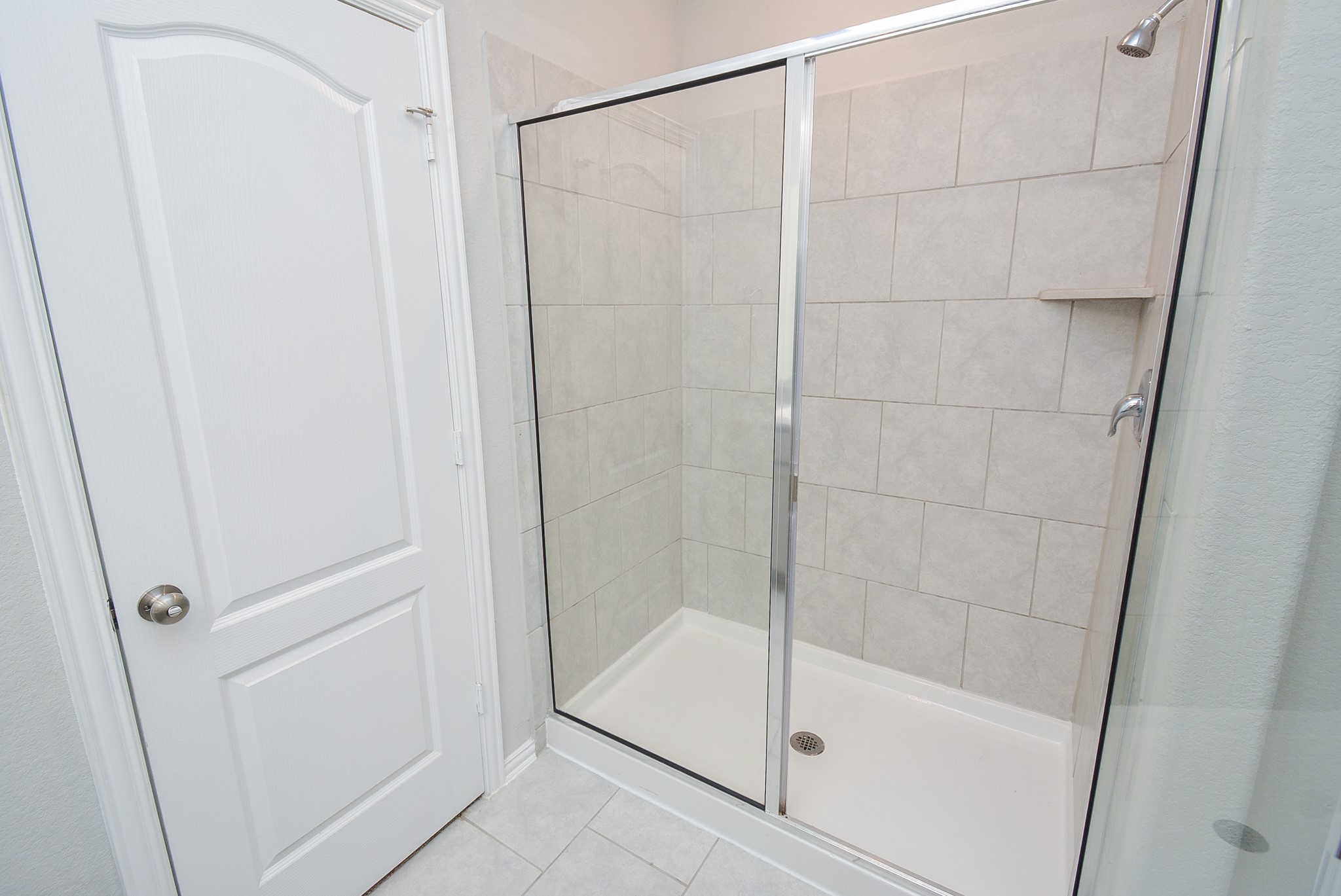 A roomy walk-in, glass enclosed shower with great big, good looking tile, is so convenient.