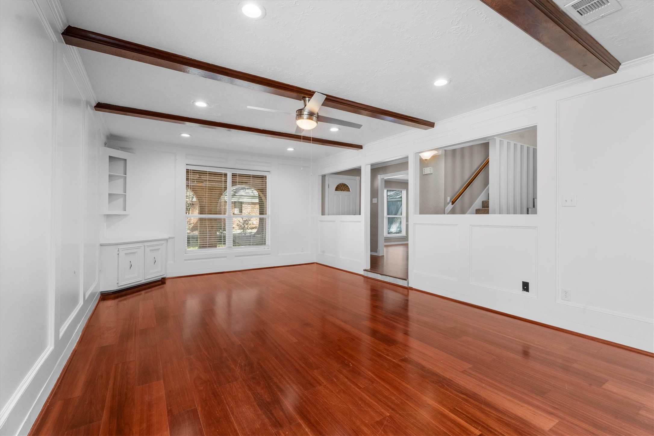 Large Family Room w/ wood floors and accented by wood beams